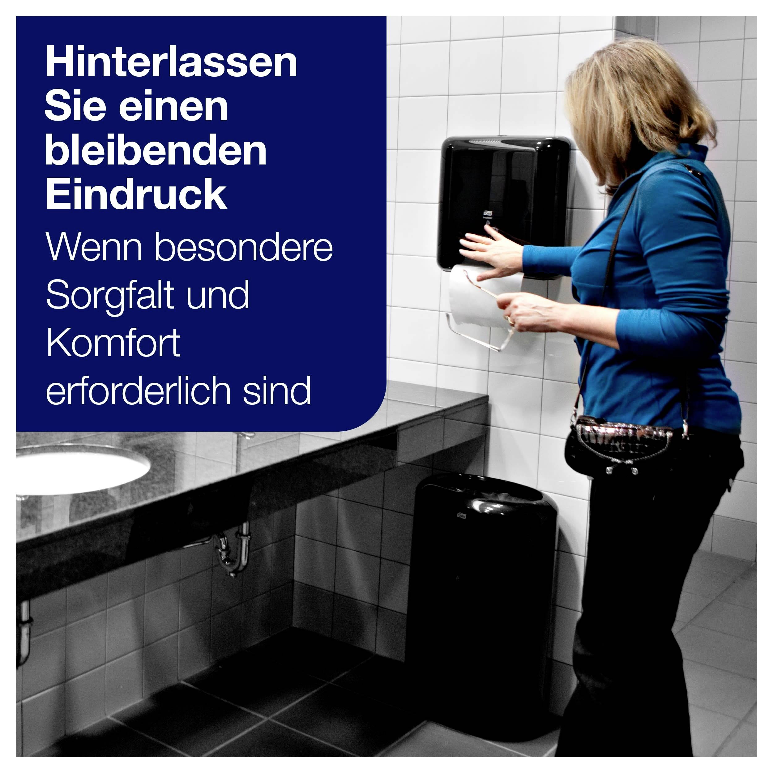 Eine Person in einem Badezimmer nutzt einen Papierspender. Text: Hinterlassen Sie einen bleibenden Eindruck. Wenn besondere Sorgfalt und Komfort erforderlich sind.
