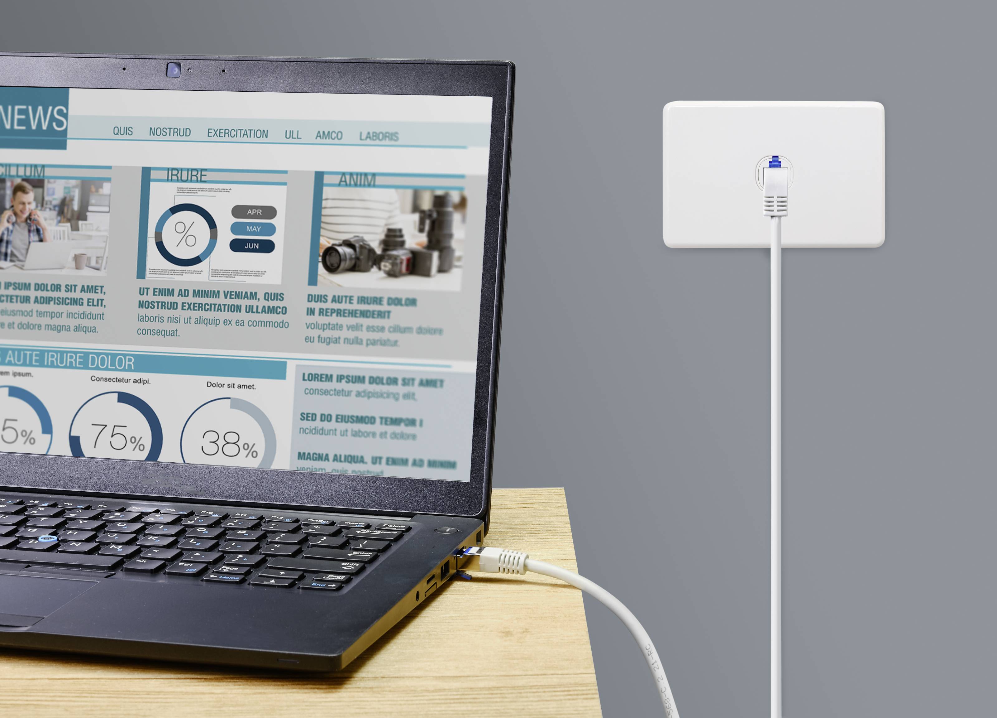 Ein Laptop ist per Ethernet-Kabel mit einer Wandbuchse verbunden; auf dem Bildschirm sind Nachrichten und statistische Daten zu sehen.