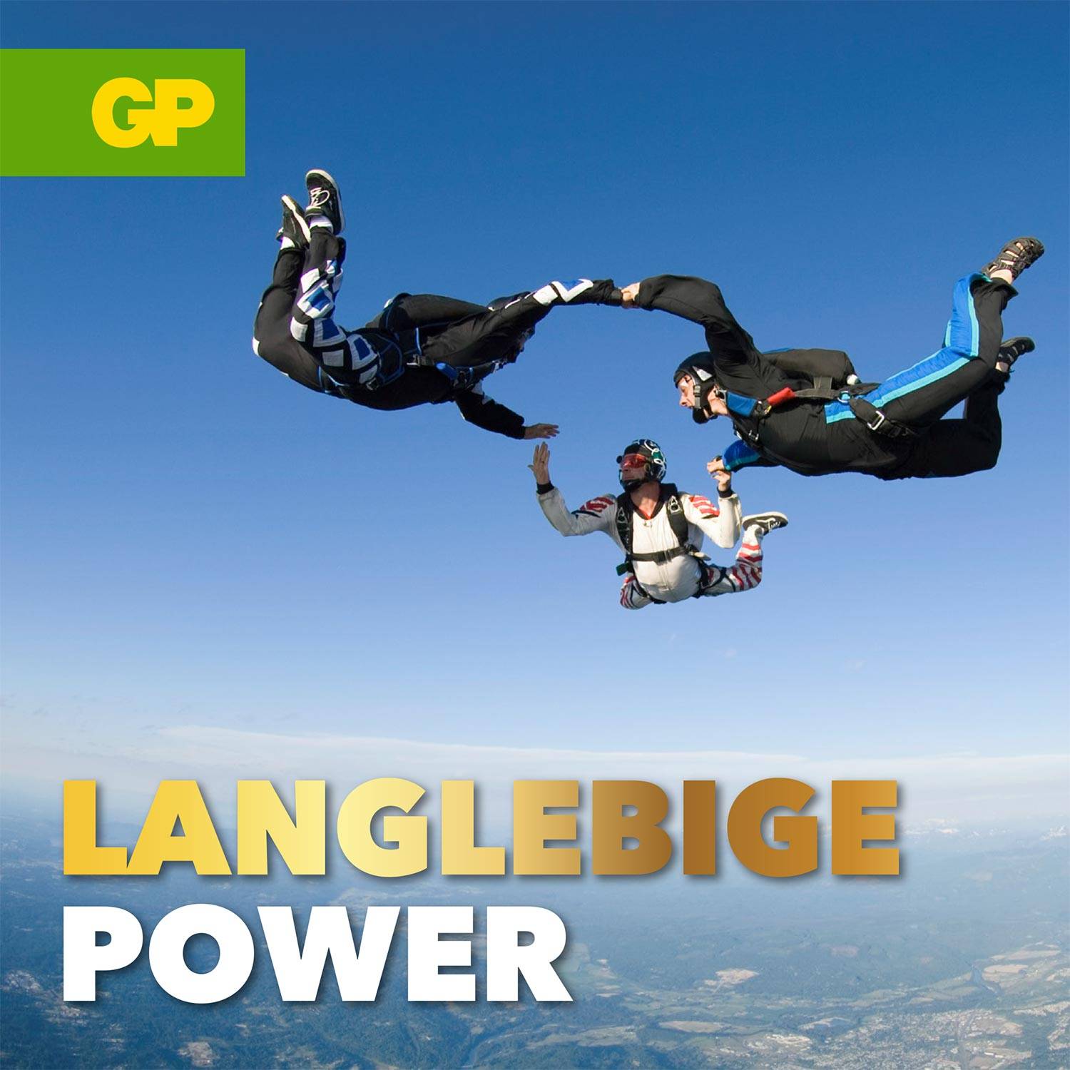 Drei Personen beim Fallschirmspringen in der Luft über einer Landschaft. Oben links 'GP'-Logo, unten der Text 'LANGLEBIGE POWER'.