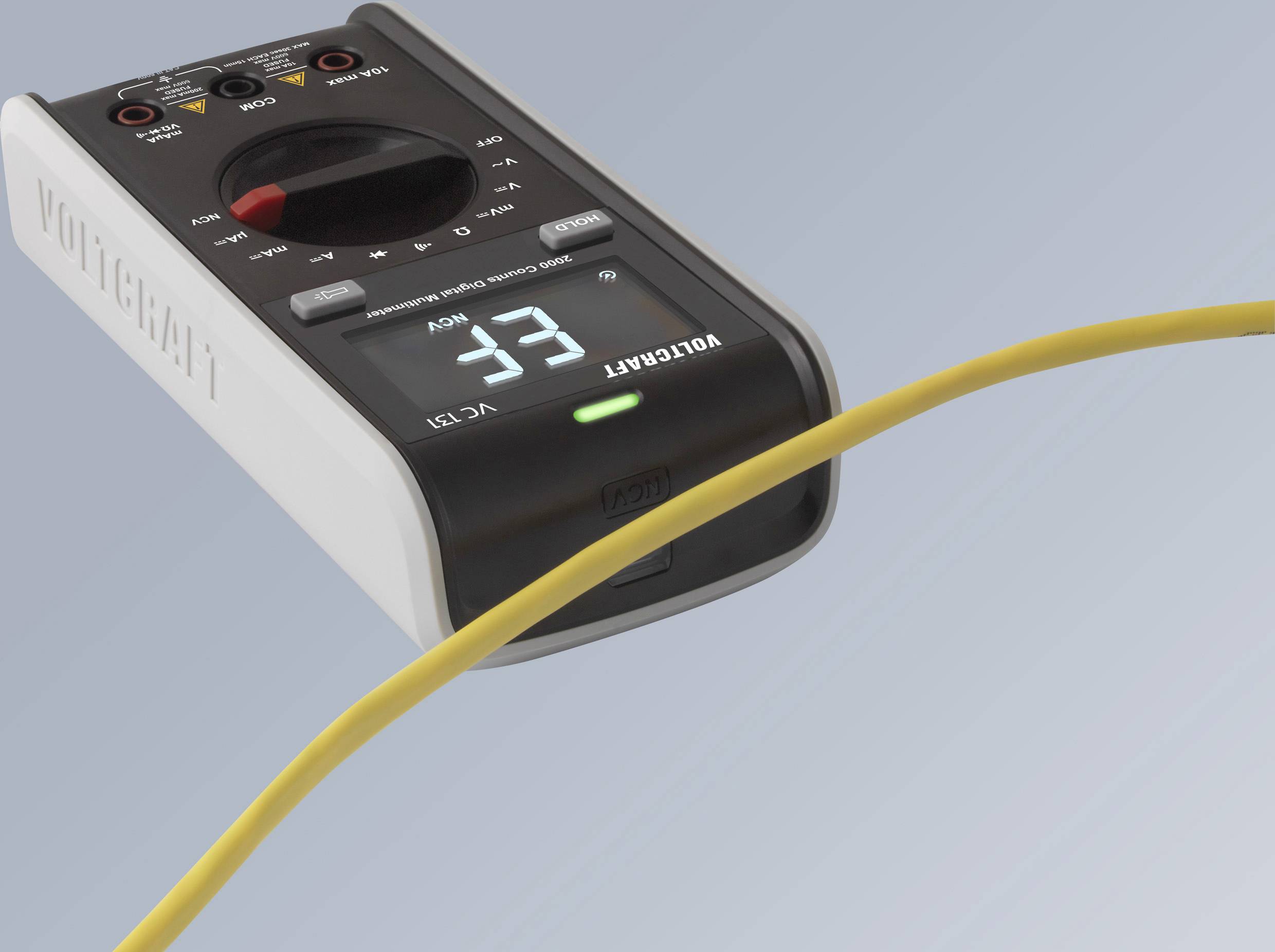 Multimeter mit gelbem Kabel, zeigt 33 an. Gerätenummer VC131 ist erkennbar, blauer Hintergrund.
