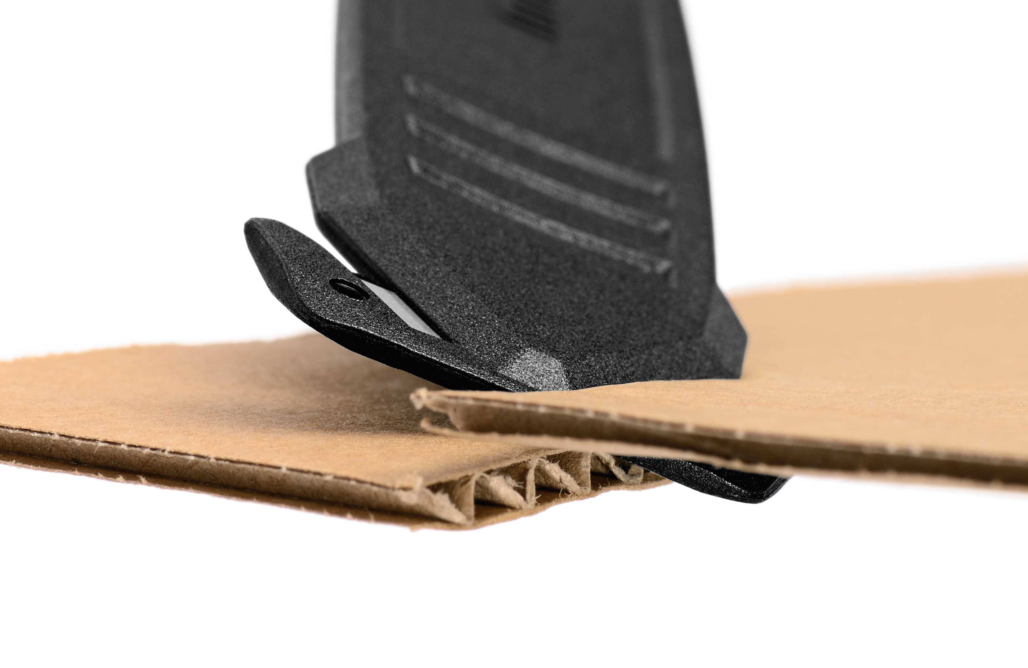 Ein Messer schneidet sauberes, sicheres Gewebe durch Pappe. Das Bild zeigt die Nahaufnahme des Schnittvorgangs auf Wellpappe.