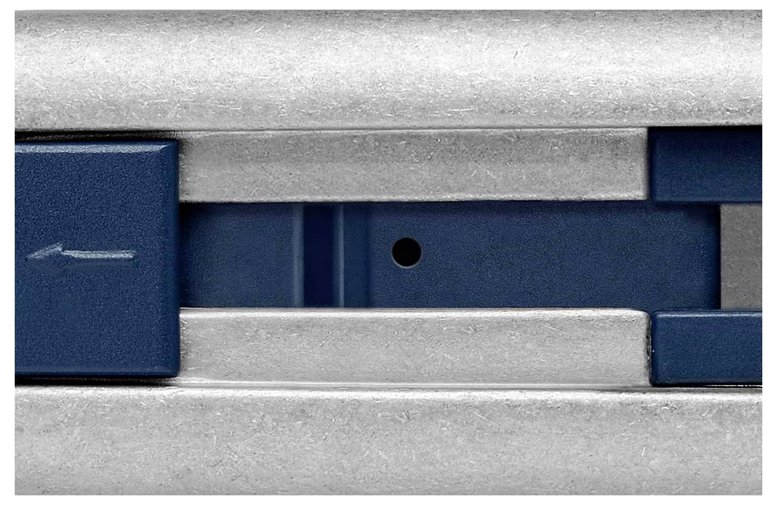 Nahaufnahme eines Metallmechanismus mit einem blauen Schieberegler und einem Pfeil, der nach links zeigt.