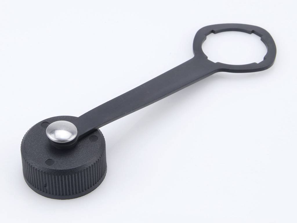 Ein schwarzer Plastikdeckelöffner mit einem drehbaren Griff und einem runden, gezahnten Ende zum Öffnen von Schraubverschlüssen.