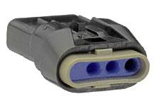 Ein schwarzer elektrischer Steckverbinder mit drei blauen Anschlüssen, liegt flach auf einer Oberfläche, Nahaufnahme.