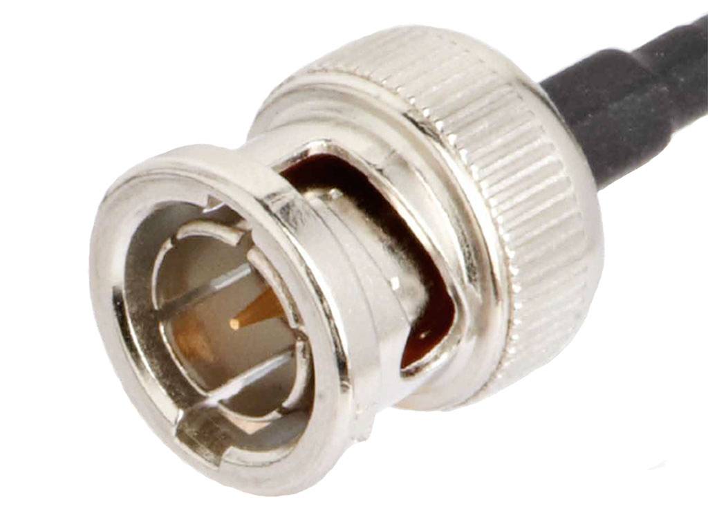 Ein silberfarbener BNC-Stecker mit geriffeltem Metallgehäuse und schwarzem Kabel, häufig genutzt für Koaxialverbindungen.