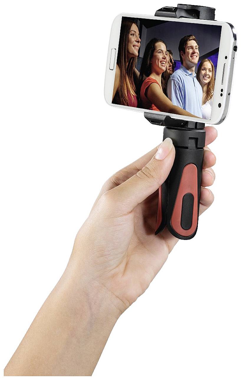 Eine Hand hält ein Smartphone mit einem Selfie-Stick, auf dem Display lächeln vier Personen in die Kamera.