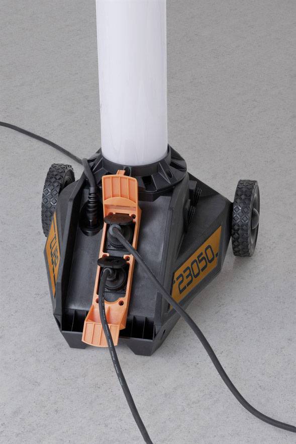 Eine orange-schwarze Maschine mit Rädern und der Nummer '23050', steht auf grauem Boden. Stromkabel sind an der Maschine angeschlossen.