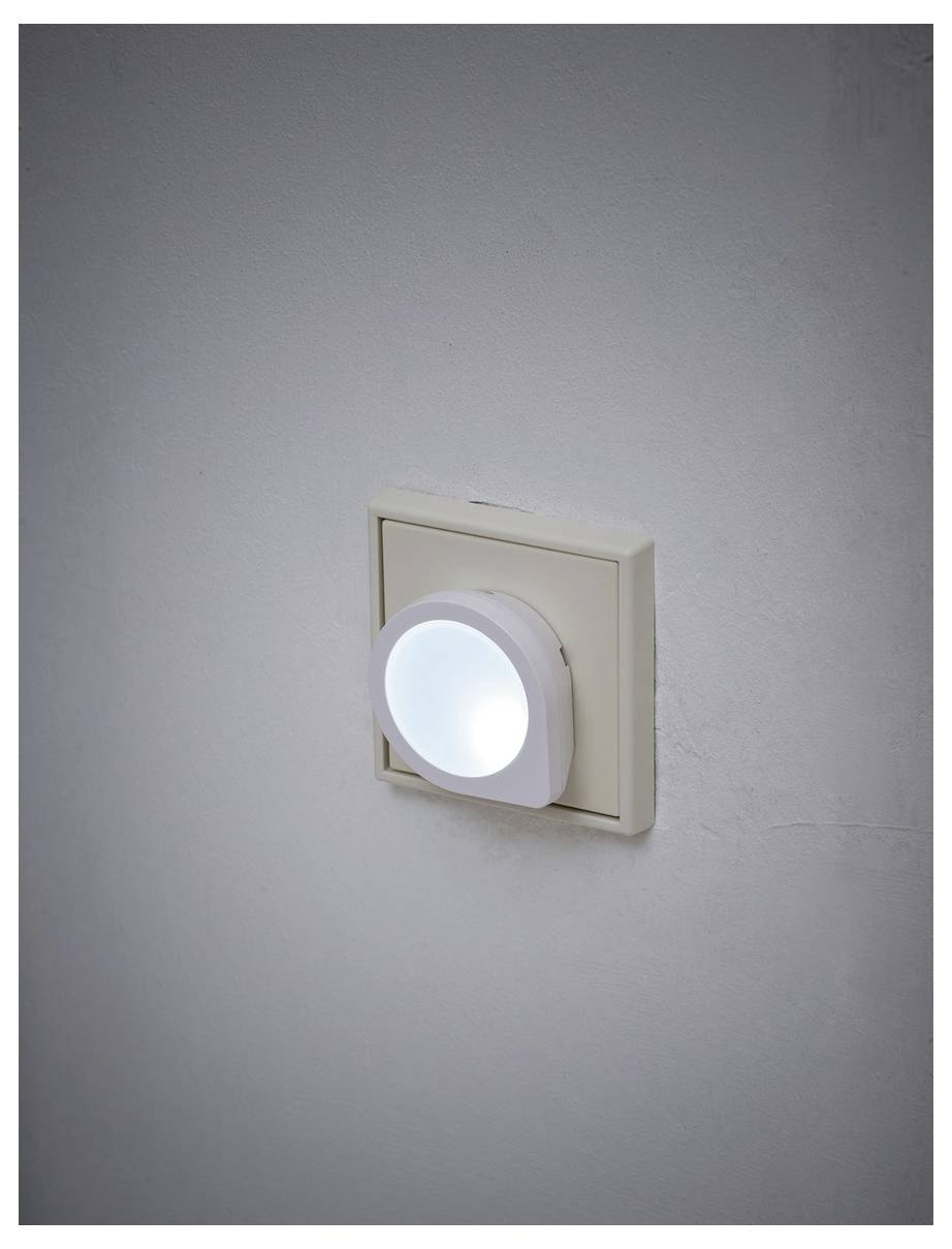 An der Wand befestigtes Nachtlicht, das sanft auf einer beigefarbenen Steckdosenplatte gegen eine schlichte graue Wand leuchtet.