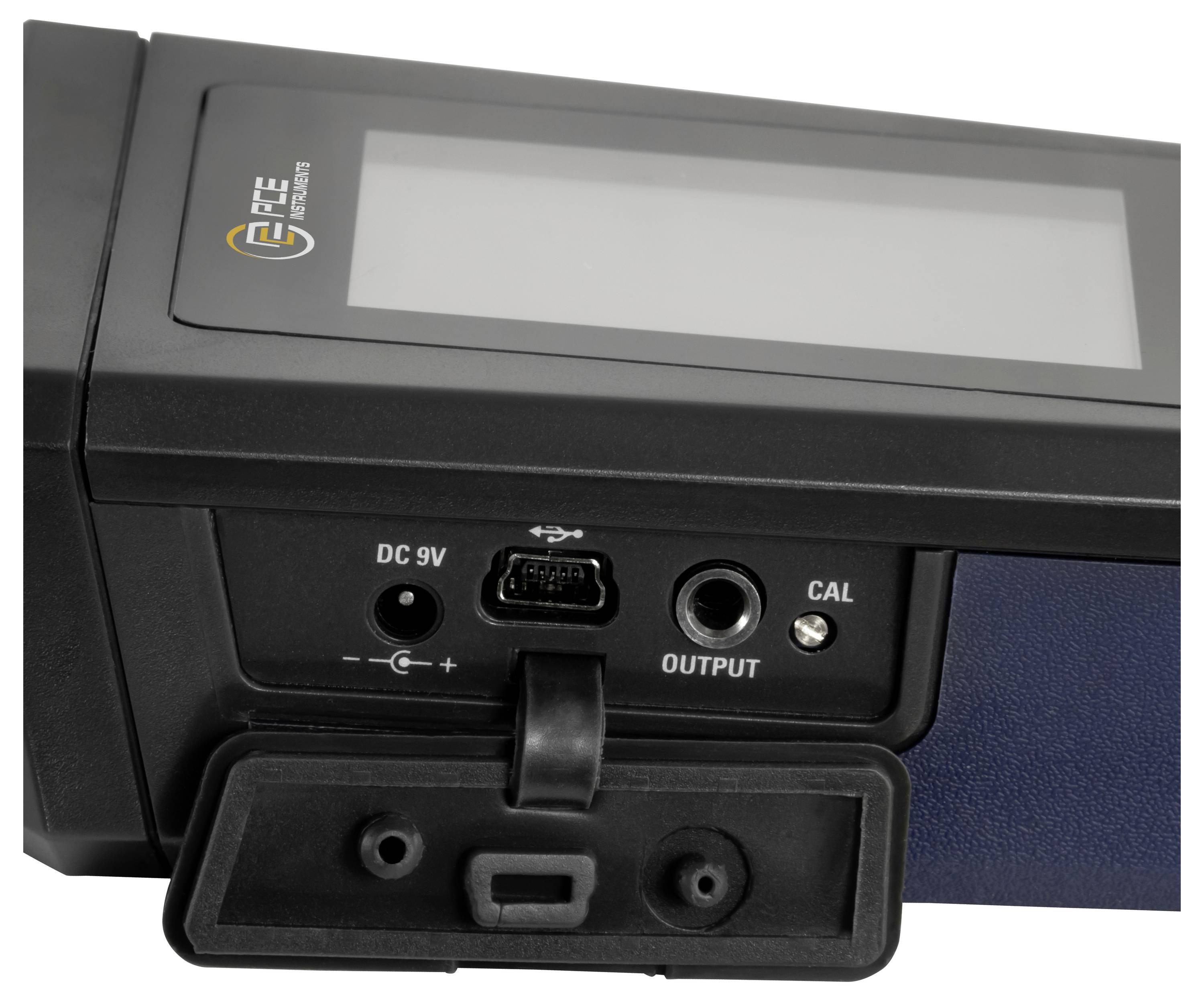 Nahaufnahme einer schwarzen Gerätesteuerplatine mit leerem Display, DC-9V-Stromeingang, USB-Anschluss, Ausgangsanschluss und kleiner CAL-Taste, wobei die Schutzabdeckung offen ist.