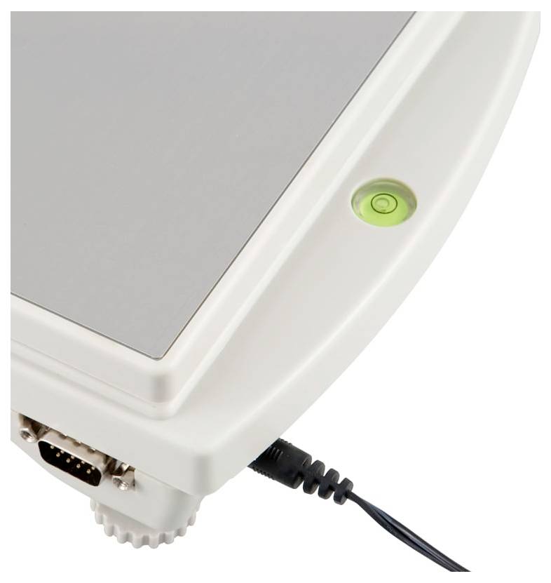 Nahaufnahme eines weißen elektronischen Geräts mit einer grünen Betriebsanzeige, einem angeschlossenen Kabel und einem Serienport in der Ecke.