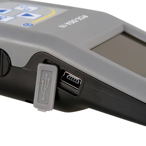 Ein graues elektronisches Gerät mit einem USB-Anschluss an der Seite. Oben sind Tasten mit Pfeilsymbolen.