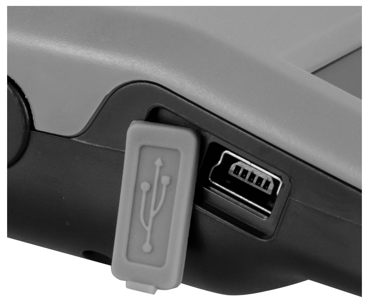 Nahaufnahme eines Geräts, das einen abgedeckten USB-Anschluss neben einem offenen USB-A-Anschluss zeigt.