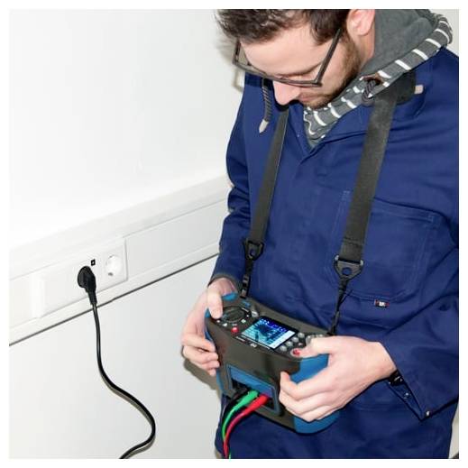 Techniker überprüft ein elektrisches Gerät und hält dabei ein Kabeltestgerät in der Nähe einer Wandsteckdose mit einem eingesteckten Kabel.