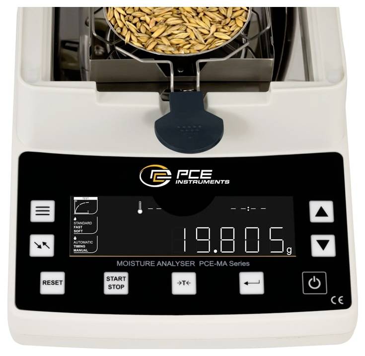 PCE Instruments Feuchtemessgerät mit einer Probenschale voller Getreide oben drauf und einer digitalen Anzeige auf der Vorderseite, die 19,805 g anzeigt.