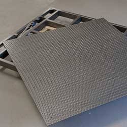 Ein grauer Kohlefaserbedarf liegt auf einer Palette mit Werkzeugen im Hintergrund.