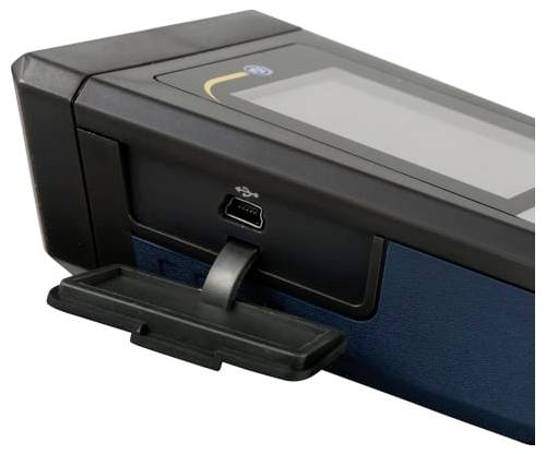 Nahaufnahme eines schwarzen elektronischen Geräts mit einem USB-Anschluss und einem kleinen Tablett oder einer Abdeckung auf der Vorderseite, dargestellt auf weißem Hintergrund.