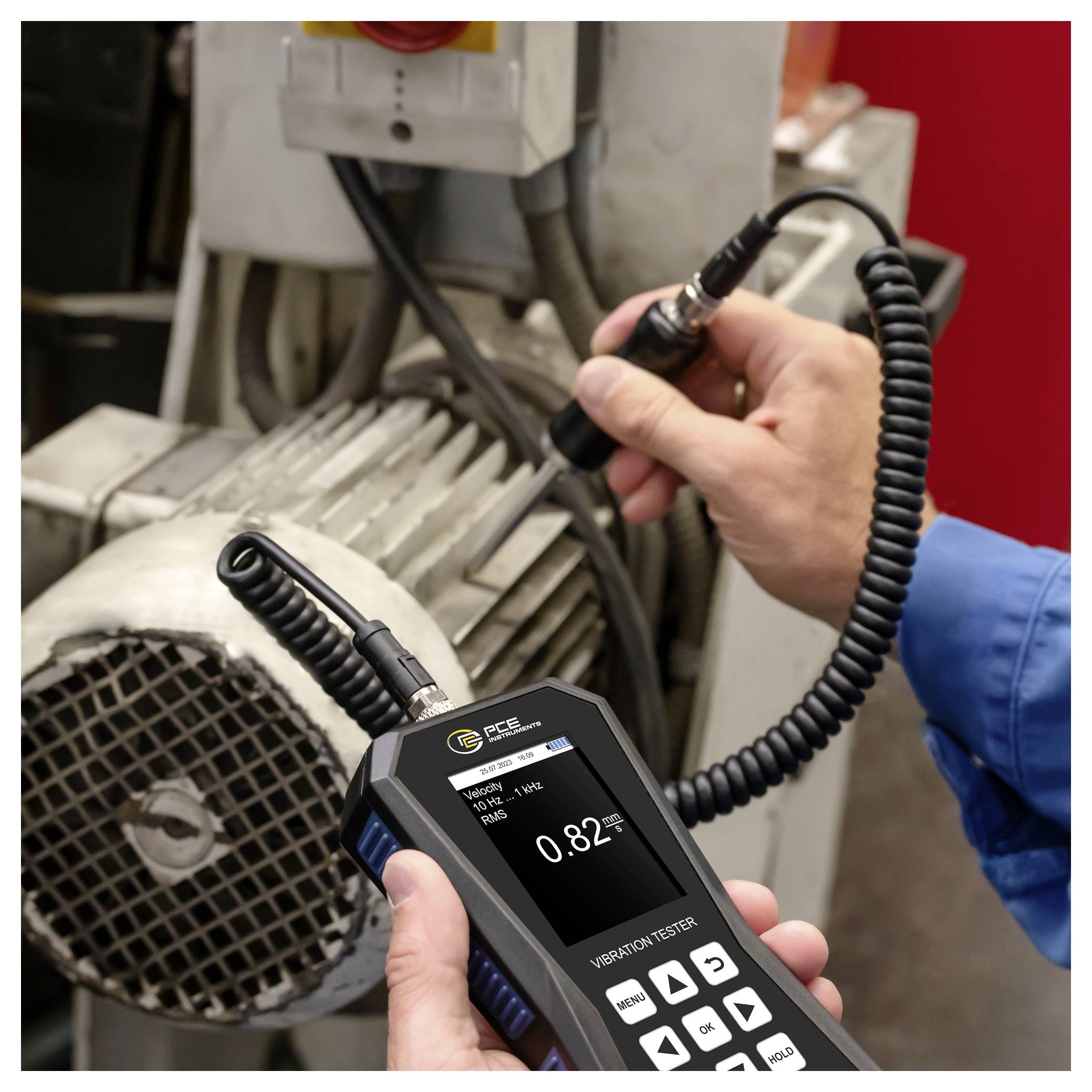 Ein Techniker verwendet ein Schwingungsprüfgerät an einem Elektromotor, wobei das Gerät eine Messung von 0,82 anzeigt.