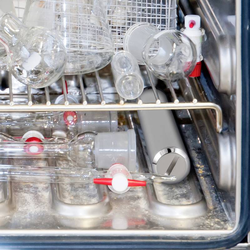 Laborgeräte aus Glas werden in einem warmen Trockenschrank getrocknet, mit einem Thermometer an der Seite zur Temperaturüberwachung.