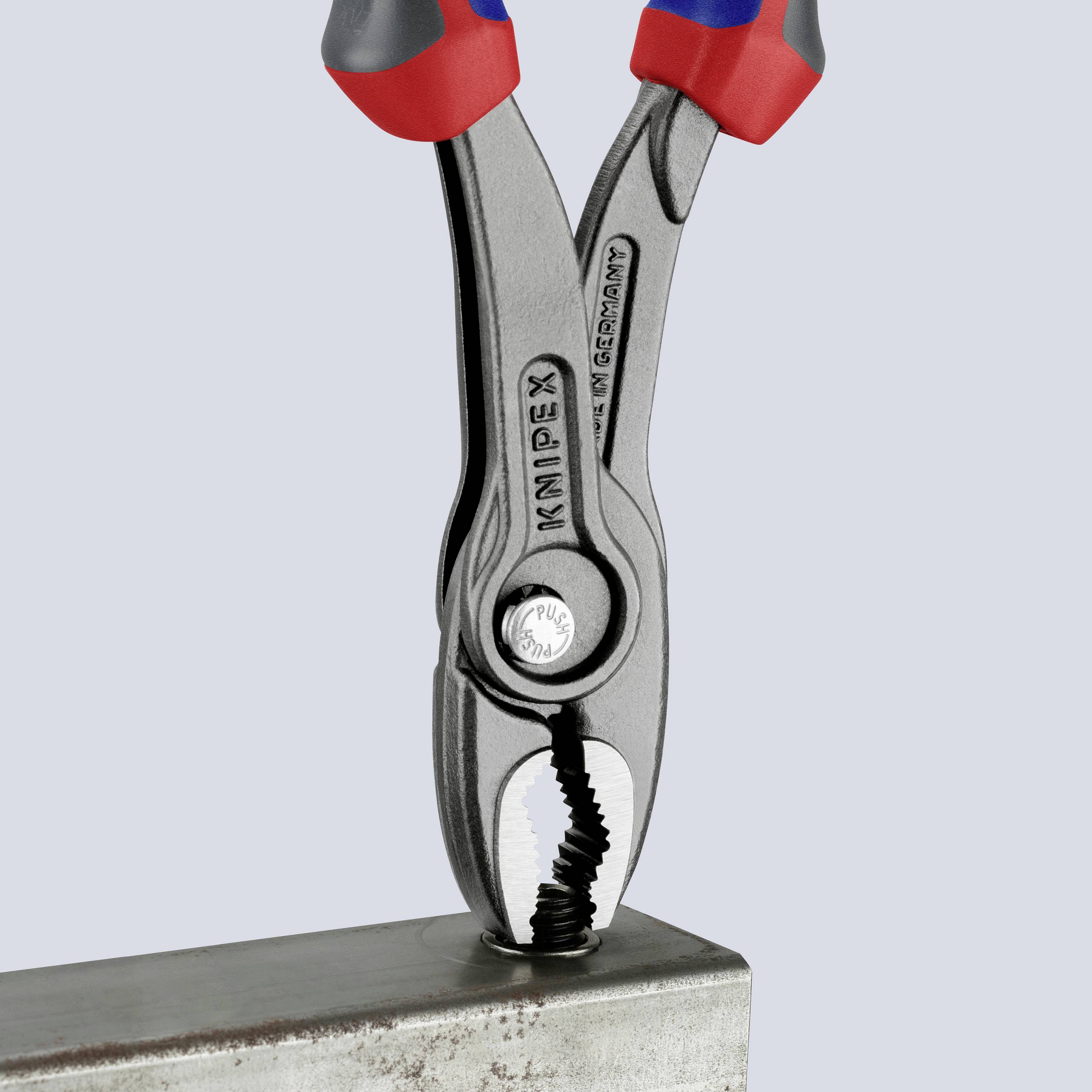Durch eine Zange wird ein Metallteil gegriffen. Die Zange hat rote und blaue Griffe.