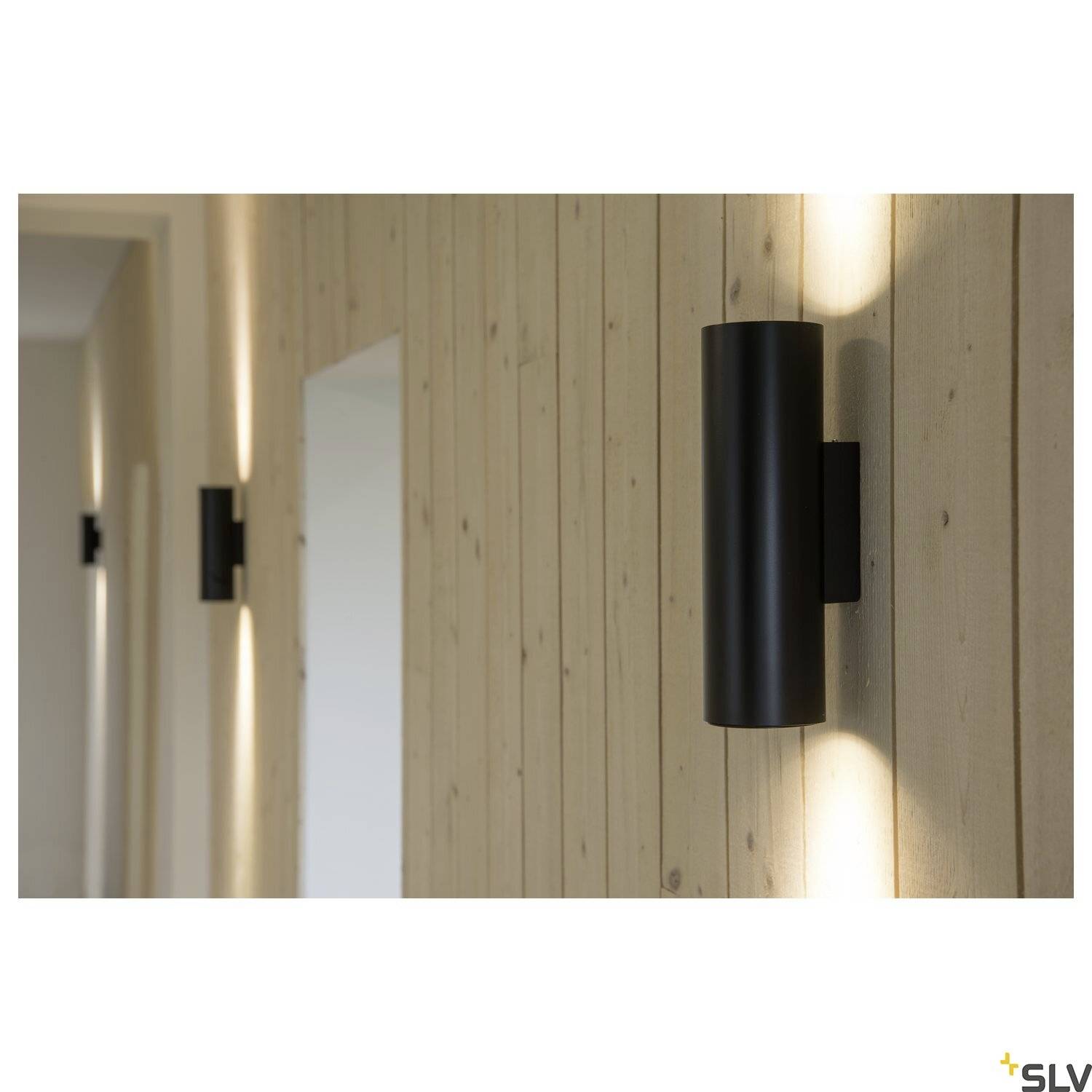 Schwarze Wandleuchten an einer hellen Holzvertäfelung erzeugen ein warmes, gerichtetes Lichtmuster nach oben und unten an der Wand.