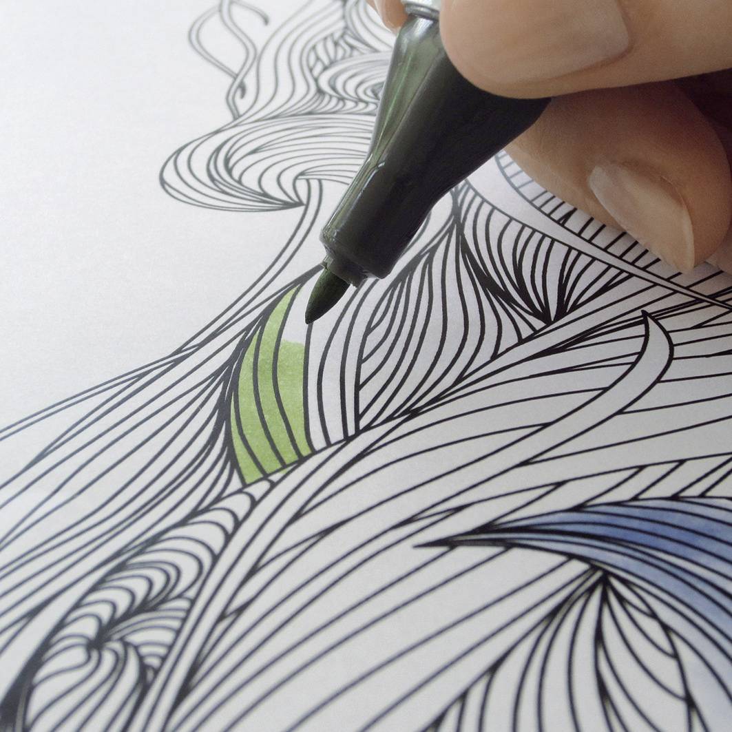 Eine Hand koloriert ein detailliertes Ausmalbild mit einem grünen Stift. Das Bild zeigt komplexe, fließende Linienmuster.