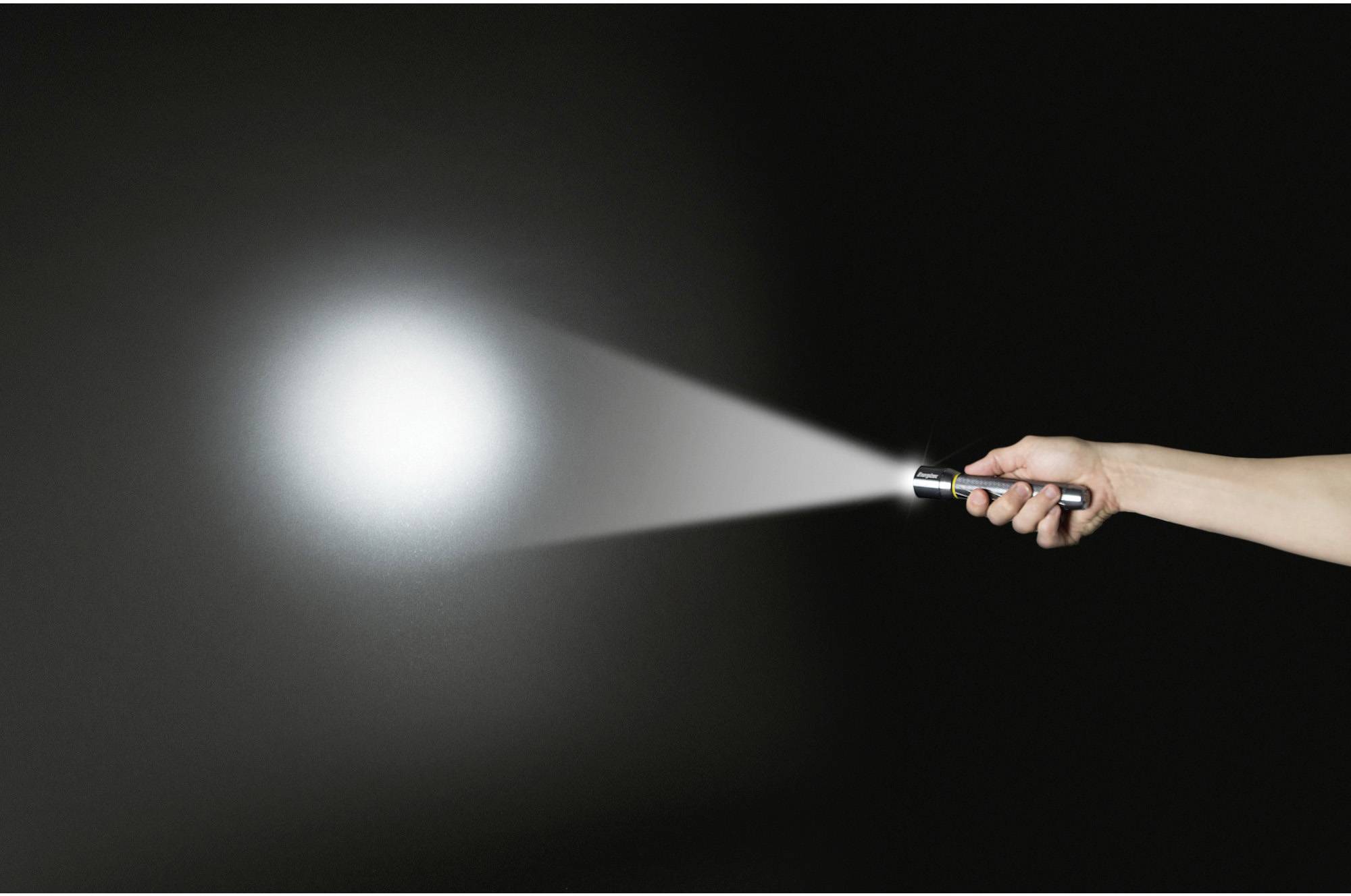 Eine Hand hält eine Taschenlampe, deren Lichtstrahl in die Dunkelheit gerichtet ist.