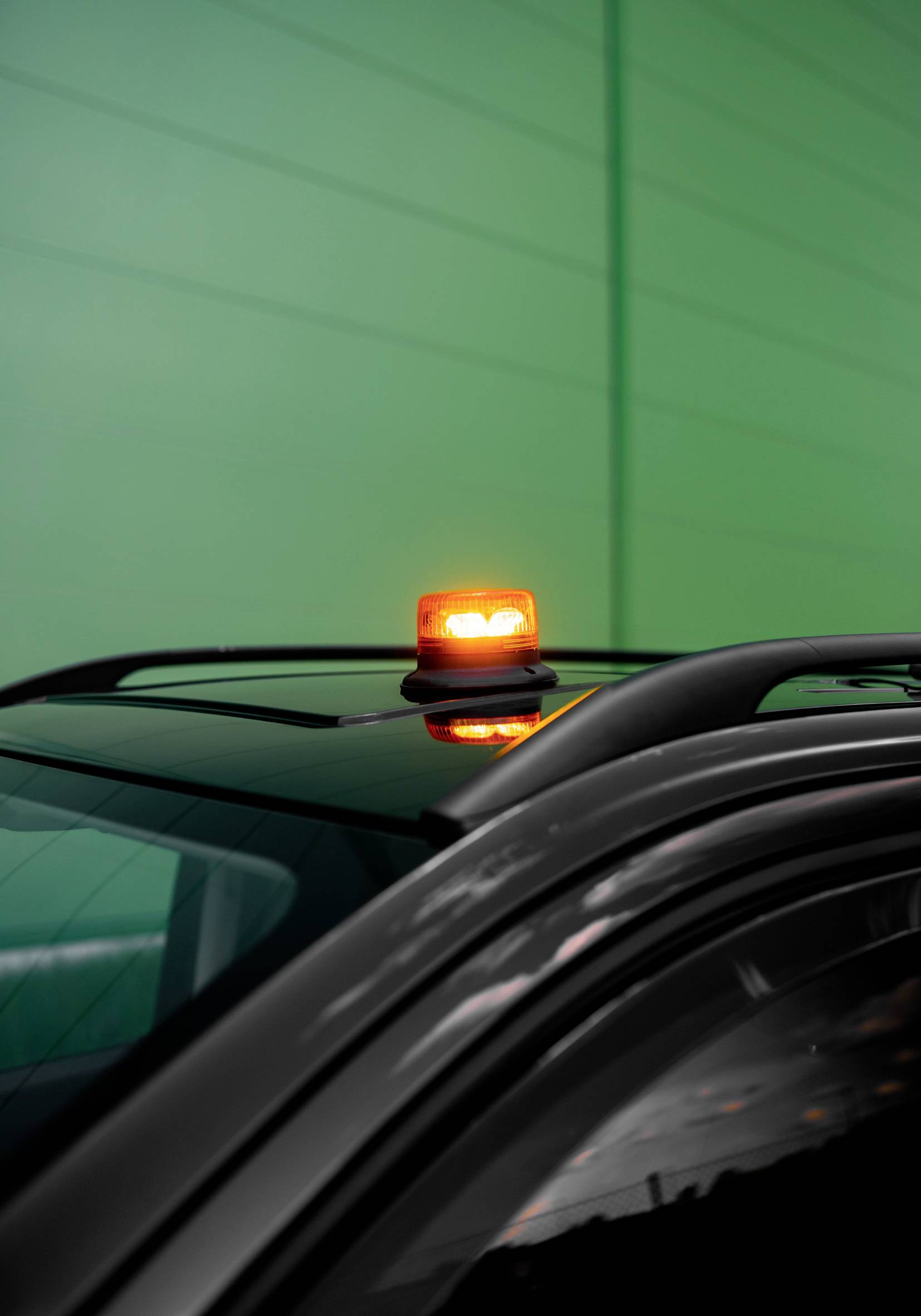 Ein Auto mit einem orangefarbenen Warnlicht auf dem Dach, blockiert.