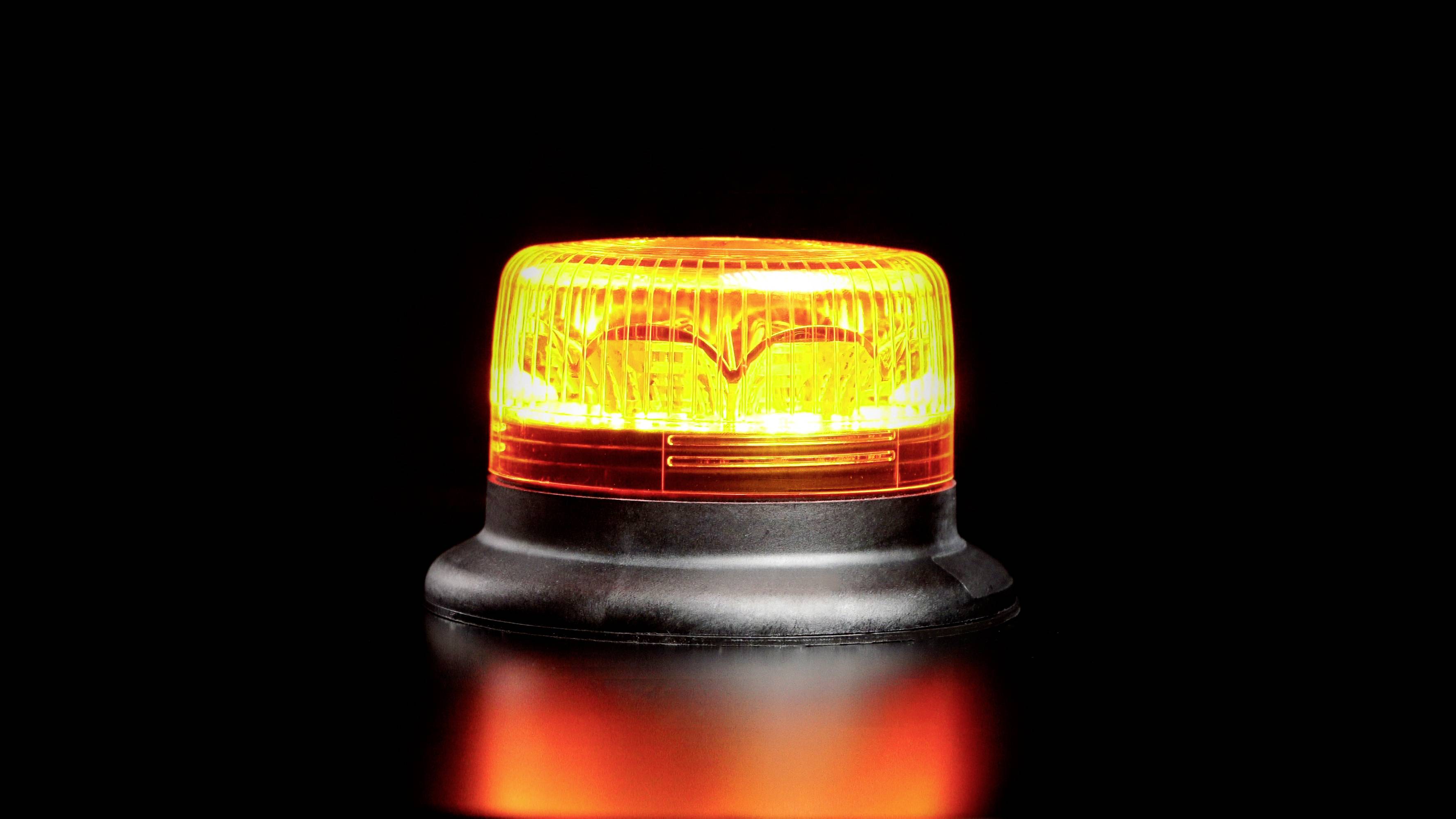 Orange Warnlicht auf schwarzem Hintergrund.
