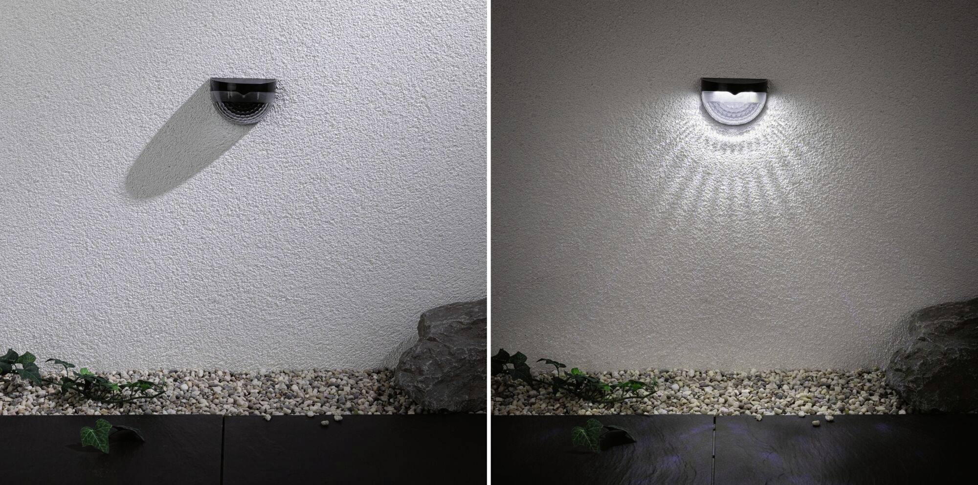 Zwei Außenlampen an einer weißen Wand über Kies und Pflanzen. Links ist die Lampe ausgeschaltet, rechts leuchtet sie mit einem kreisförmigen Muster.