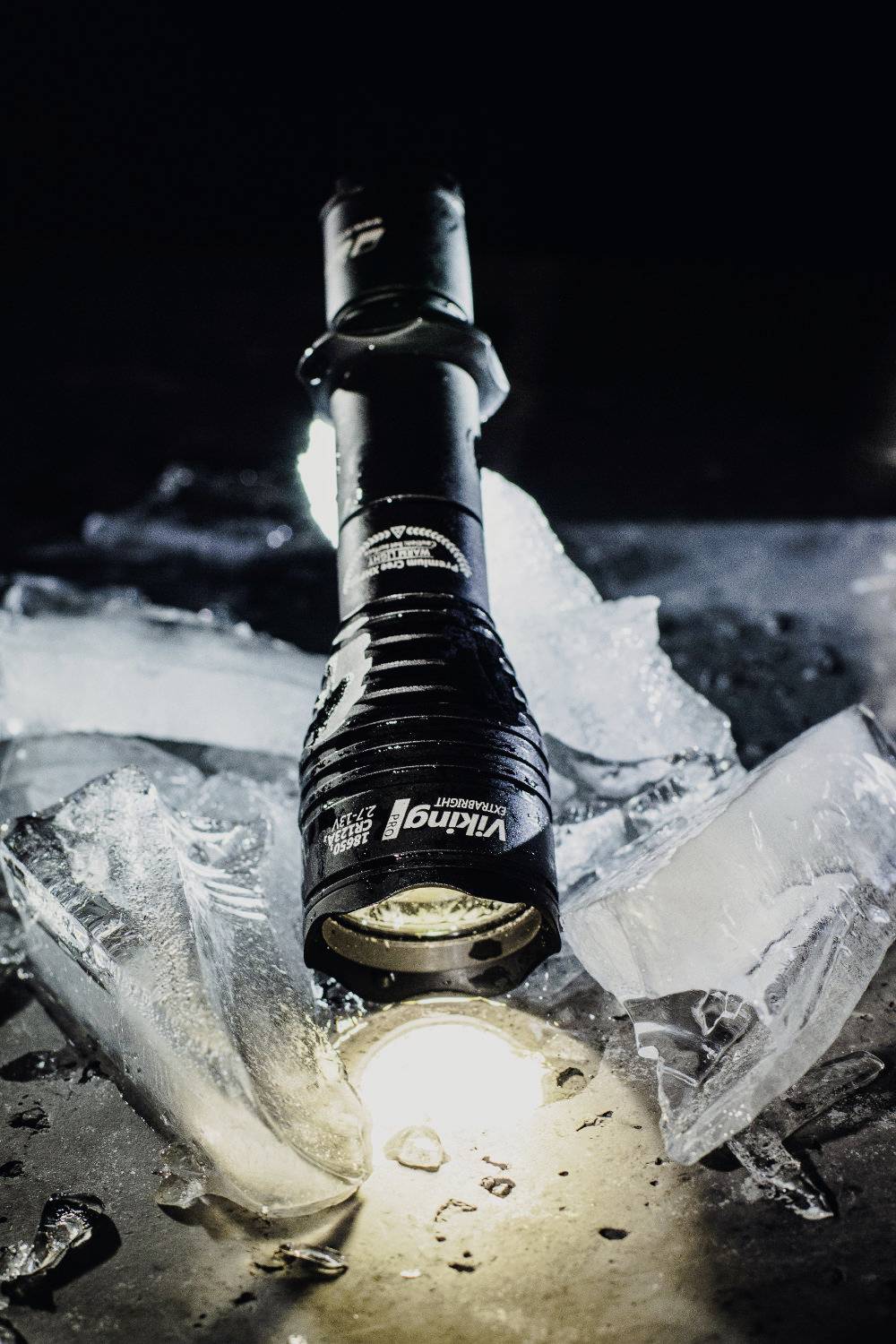 Taschenlampe leuchtet auf zerbrochenes Eis in dunkler Umgebung. Die Szene wirkt dramatisch und geheimnisvoll.