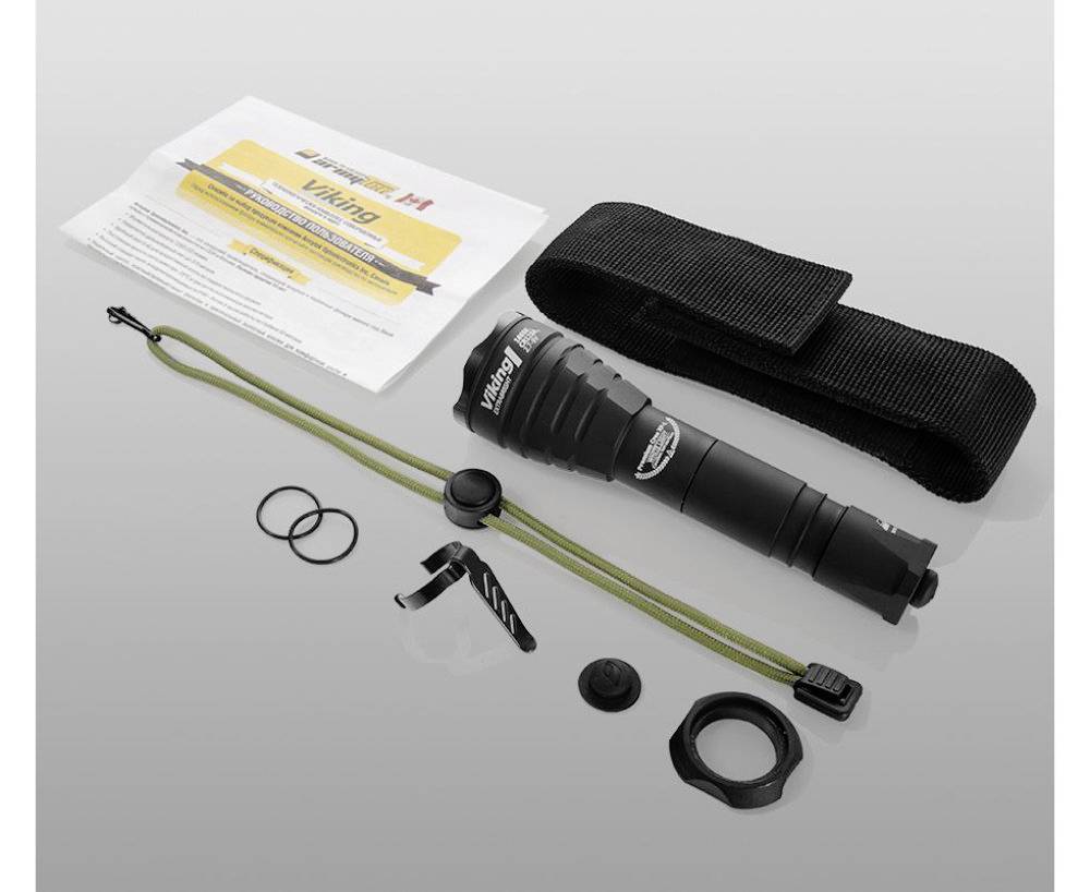 Taschenlampe-Set mit Anleitung, Trageschlaufe, Gürtelclip, Dichtungen und Halterung auf grauem Hintergrund.