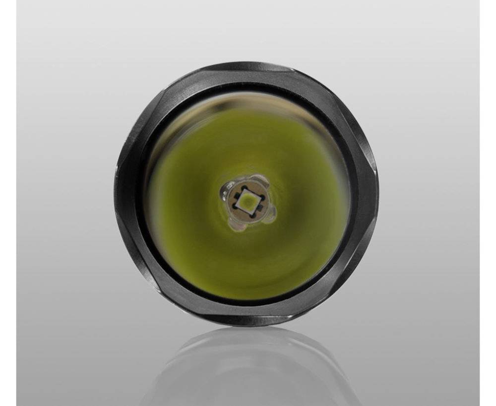 Nahaufnahme einer runden LED-Lampe mit gelbem Leuchtmittel in der Mitte, umgeben von einem silbernen Gehäuse vor grauem Hintergrund.