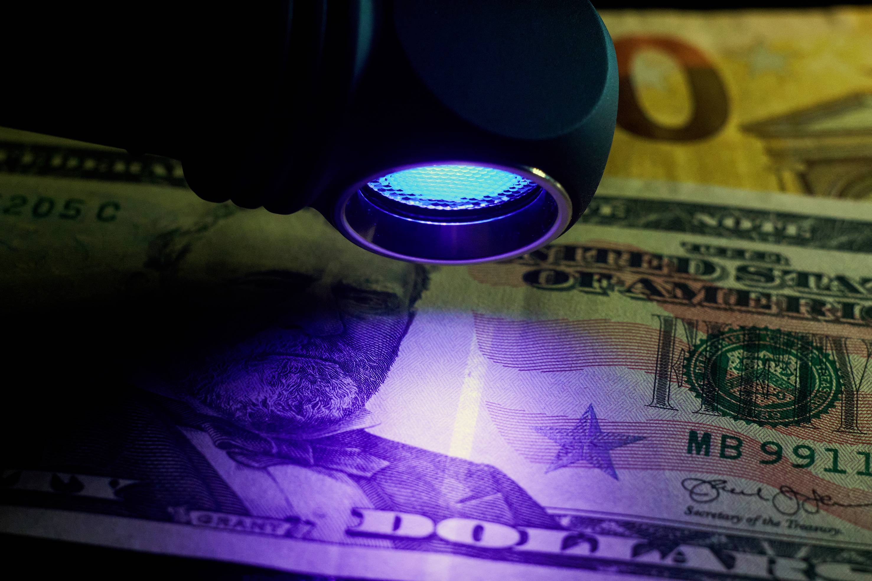Eine Banknote unter UV-Licht zeigt Sicherheitsmerkmale zur Überprüfung der Echtheit.