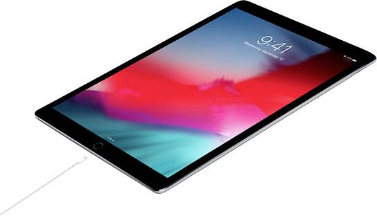 Ein Tablet, leicht schräg liegend, wird aufgeladen. Der Bildschirm zeigt die Uhrzeit 9:41 und ein farbenfrohes Hintergrundbild.