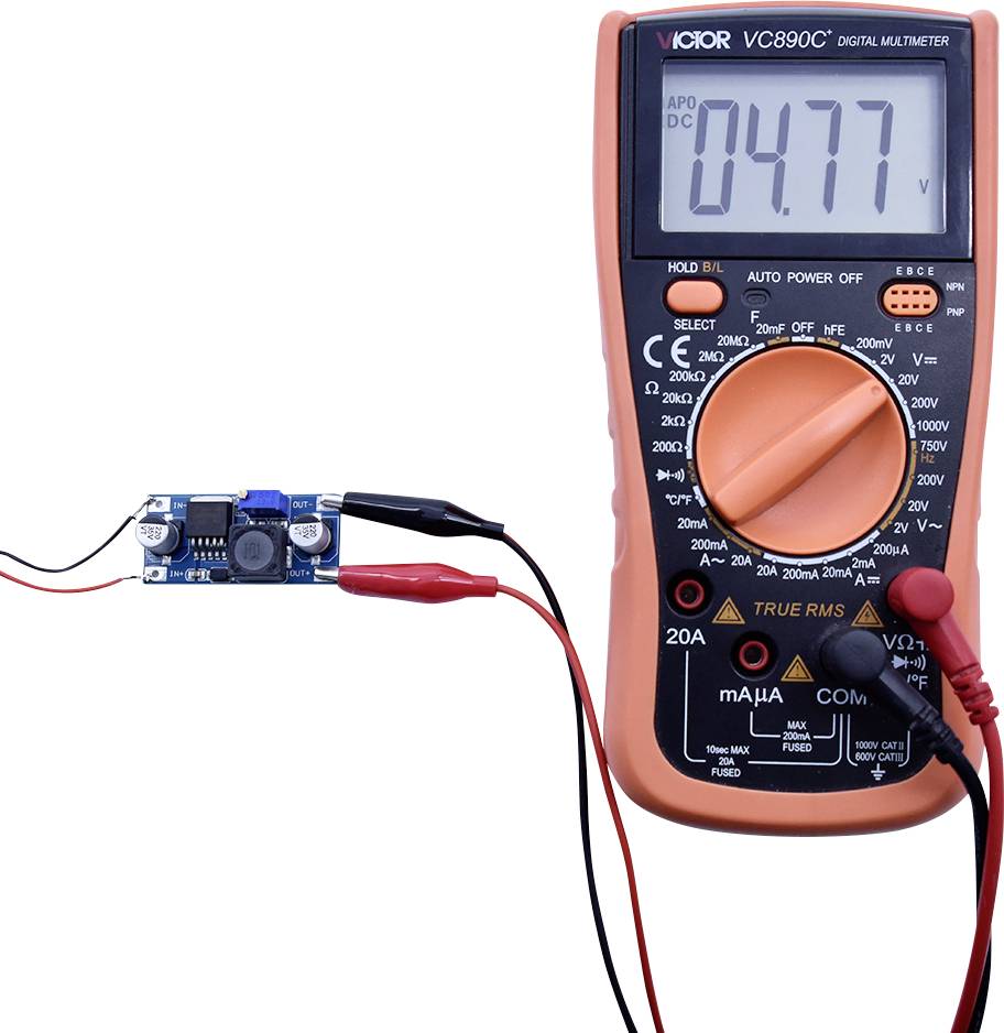 Ein Digitalmultimeter zeigt '4.77 V' an, während es mit einem elektronischen Modul verbunden ist.