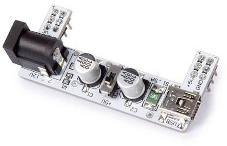 Eine elektronische Leiterplatte mit mehreren Anschlüssen, zwei großen Kondensatoren, einem USB-Anschluss, und Strombuchsen.