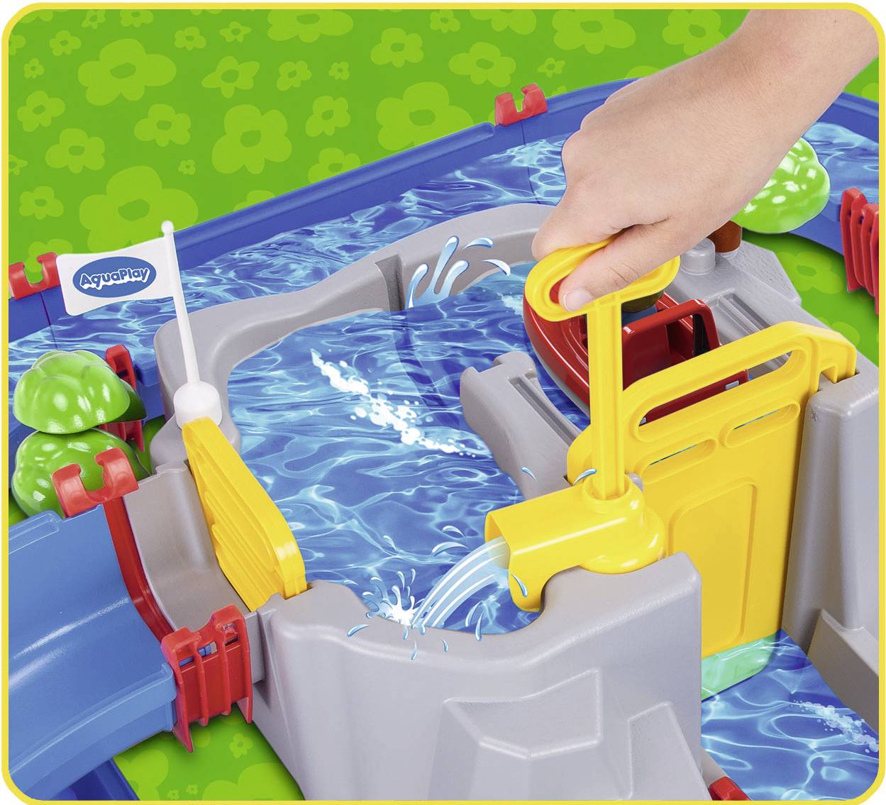Ein Wasserspielzeug mit Kanälen und Schleusen. Eine Hand betätigt eine gelbe Pumpe, Wasser fließt durch die Kanäle.