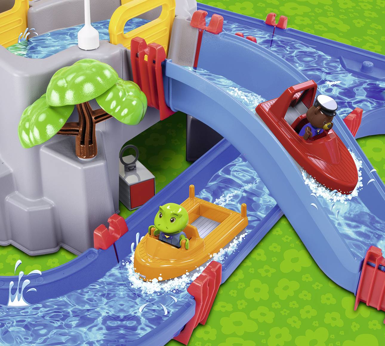 Zwei Spielzeugfiguren in farbigen Booten fahren auf Wasserbahnen. Ein Boot ist orange, das andere rot. Umgebung mit bunten Details.
