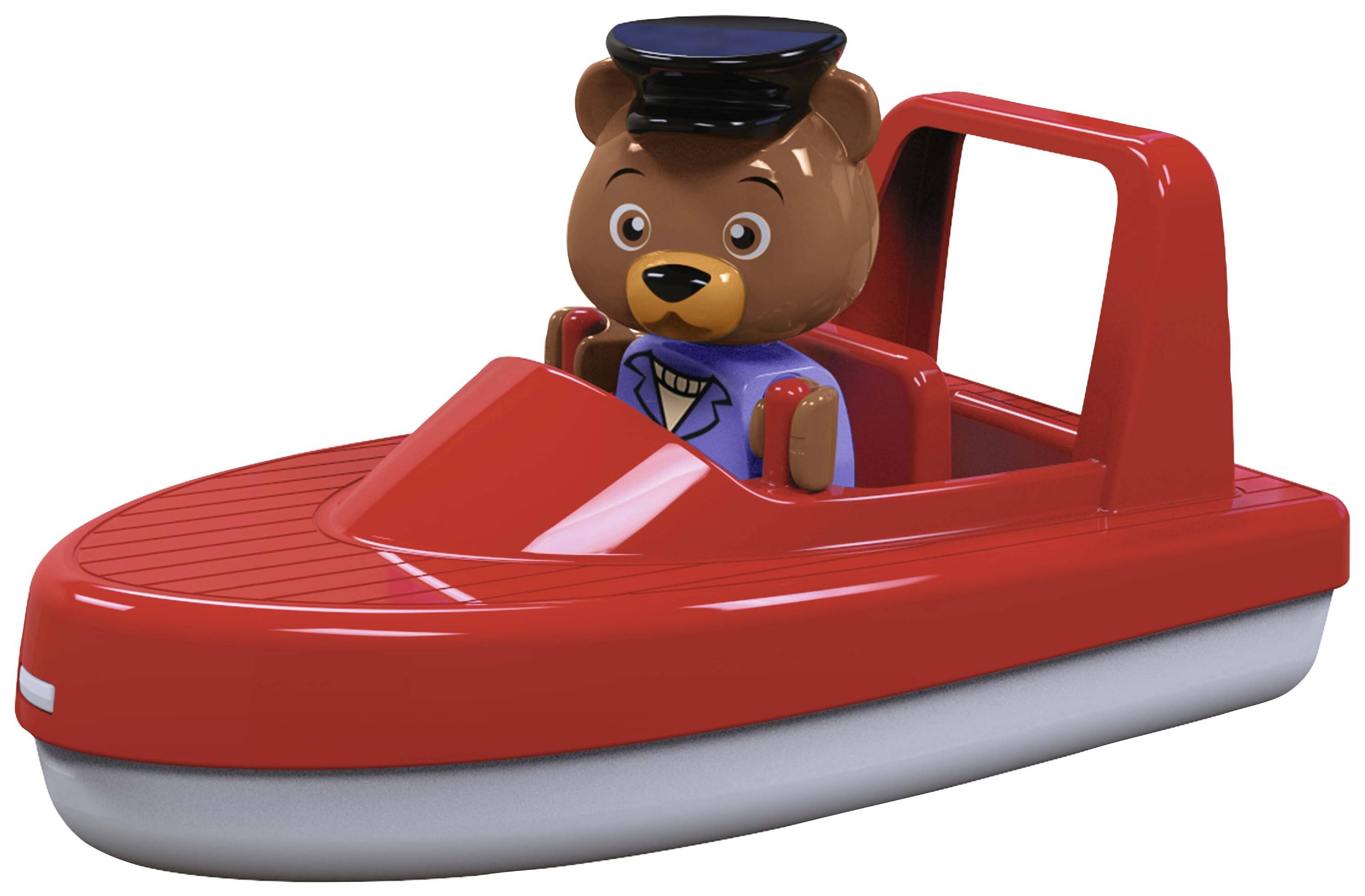 Ein Stofftier in einem Kapitänsanzug sitzt in einem roten Spielzeugboot mit rotem Dach und schwarzem Kapitänshut.