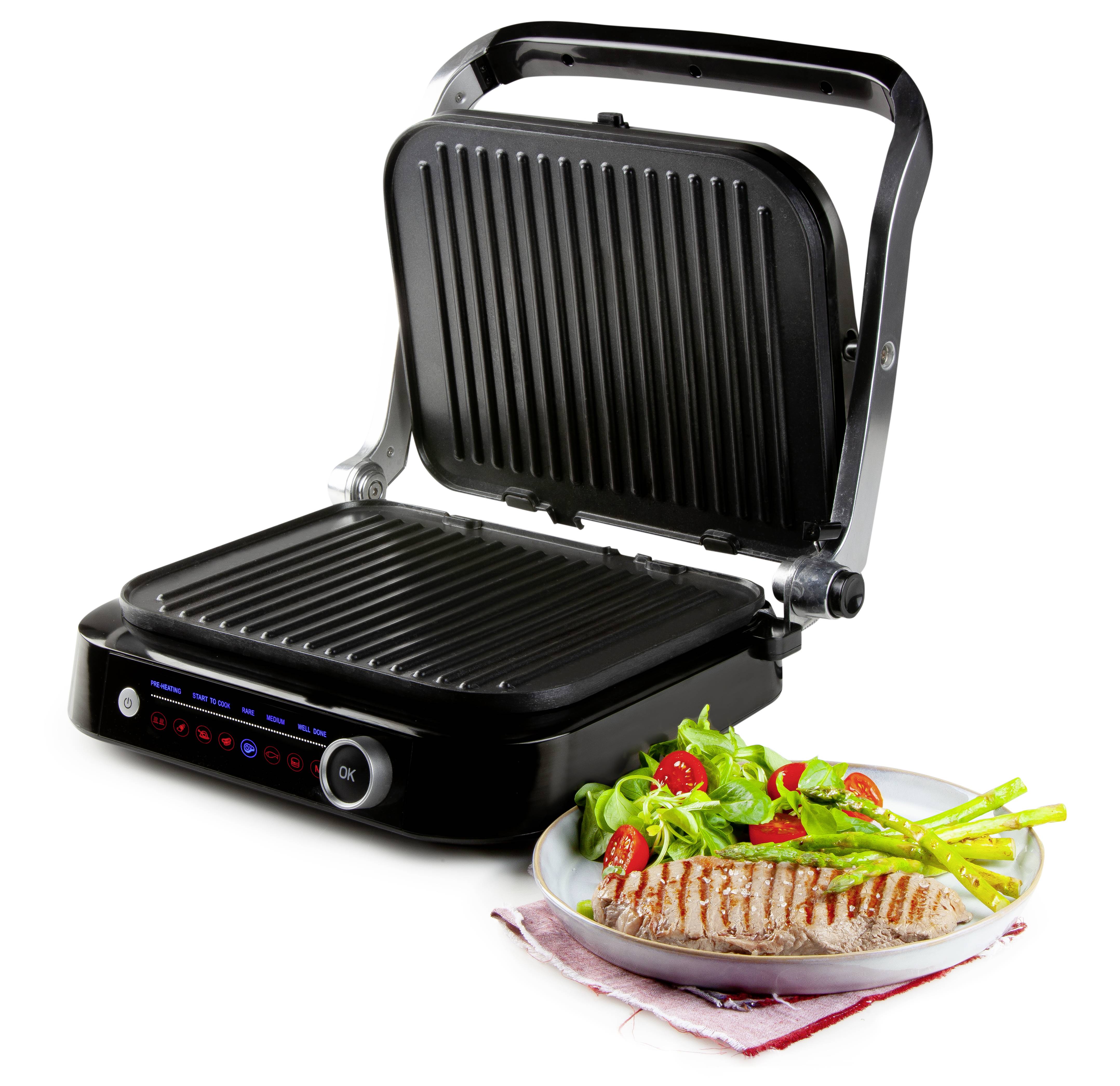 Ein geöffneter Elektrogrill neben einem Teller mit gegrilltem Hähnchenbrustfilet, Spargel und Salat.