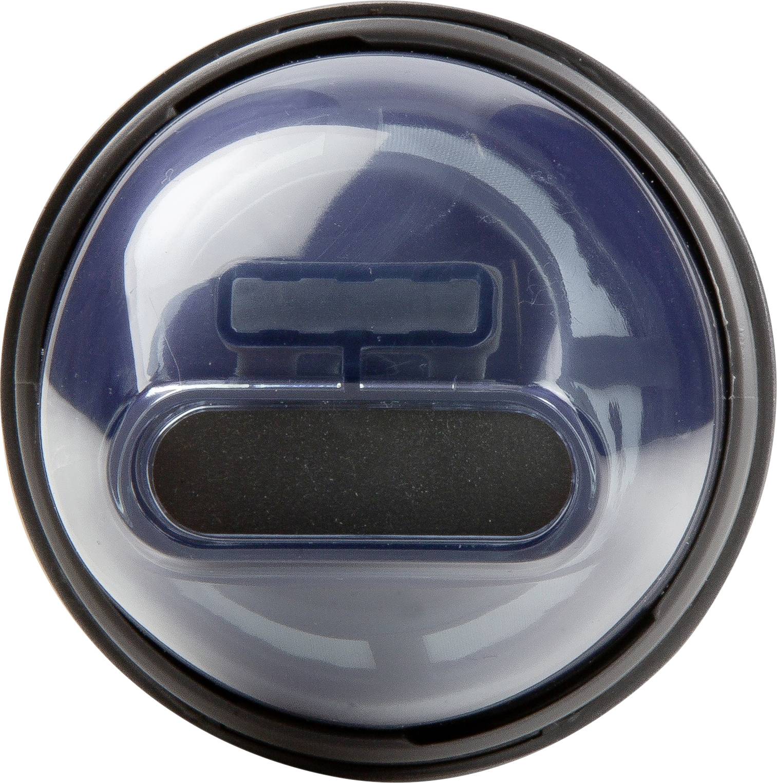 Eine runde, dunkle Kunststoffabdeckung mit durchsichtiger Oberfläche. Sie zeigt eine rechteckige Aussparung in der Mitte.