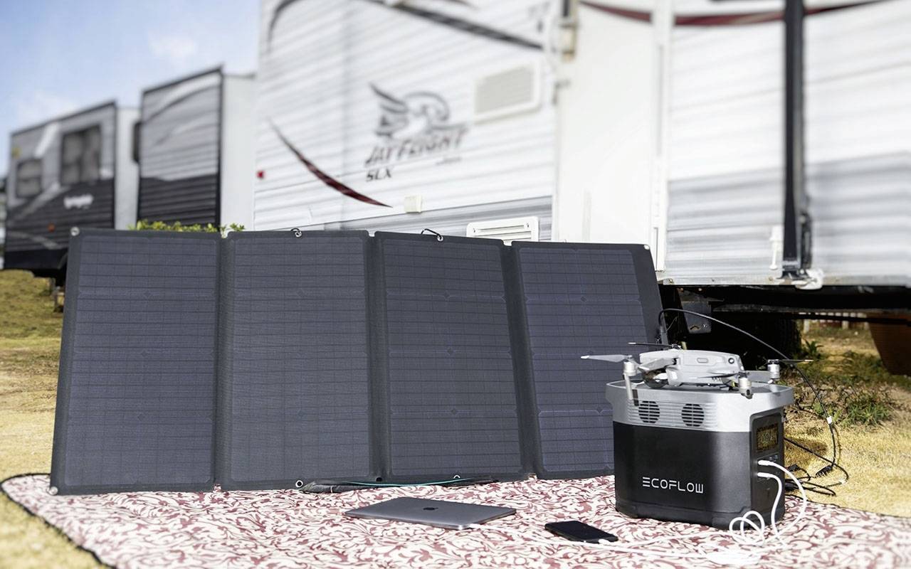 Solarpanel und tragbarer Generator auf Decke vor Wohnmobilen. Gerät lädt elektronische Geräte auf, um umweltfreundliche Energie zu nutzen.