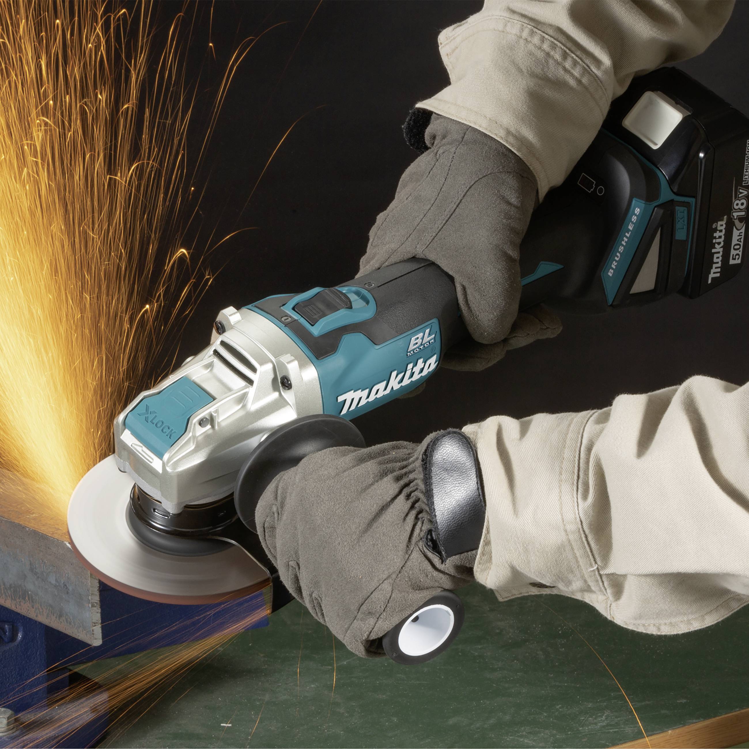 Eine Person schleift Metall mit einem Winkelschleifer, Funken fliegen. Der Winkelschleifer ist von der Marke Makita.