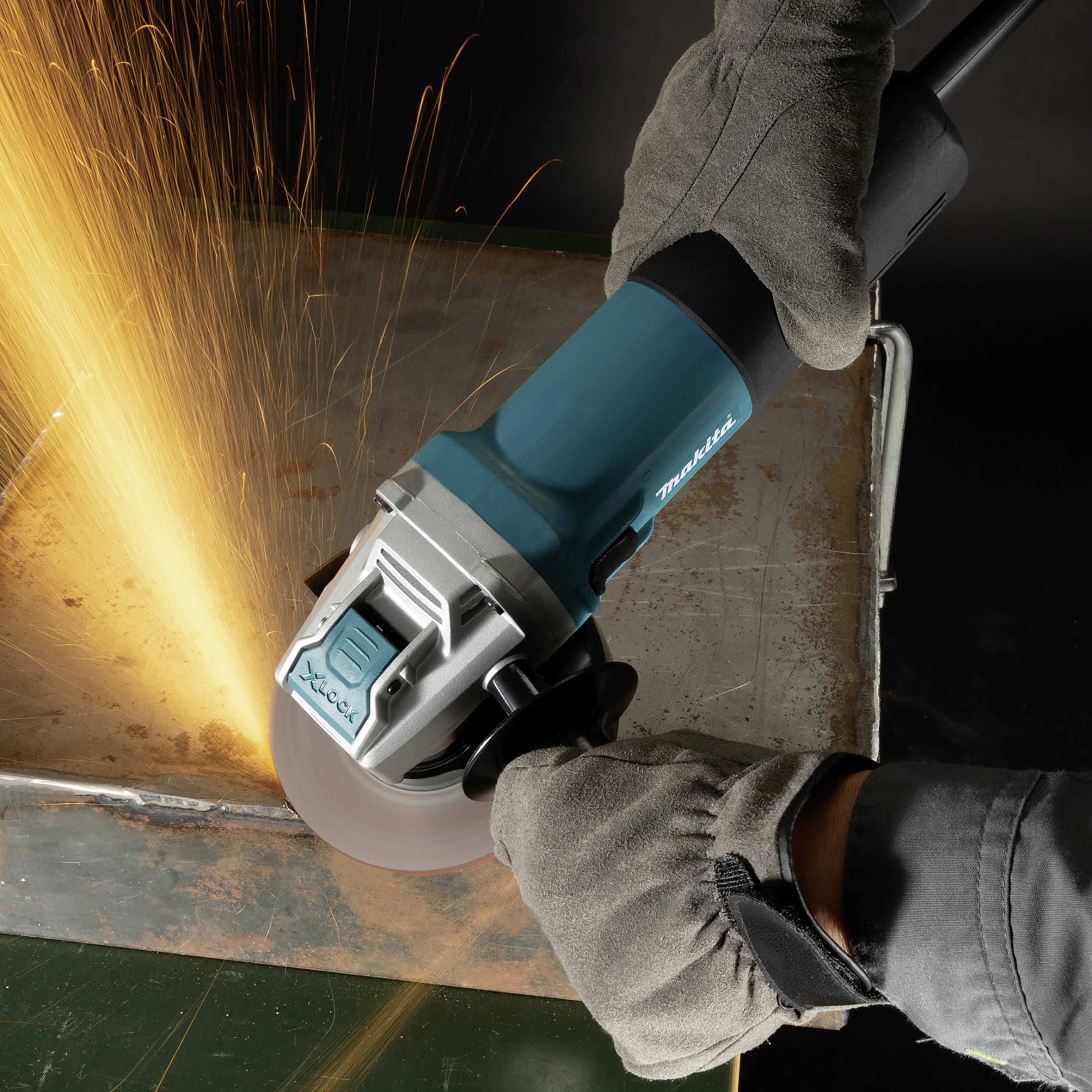 Eine Winkelschleifermaschine erzeugt Funken, während eine Person mit Handschuhen Metall bearbeitet.
