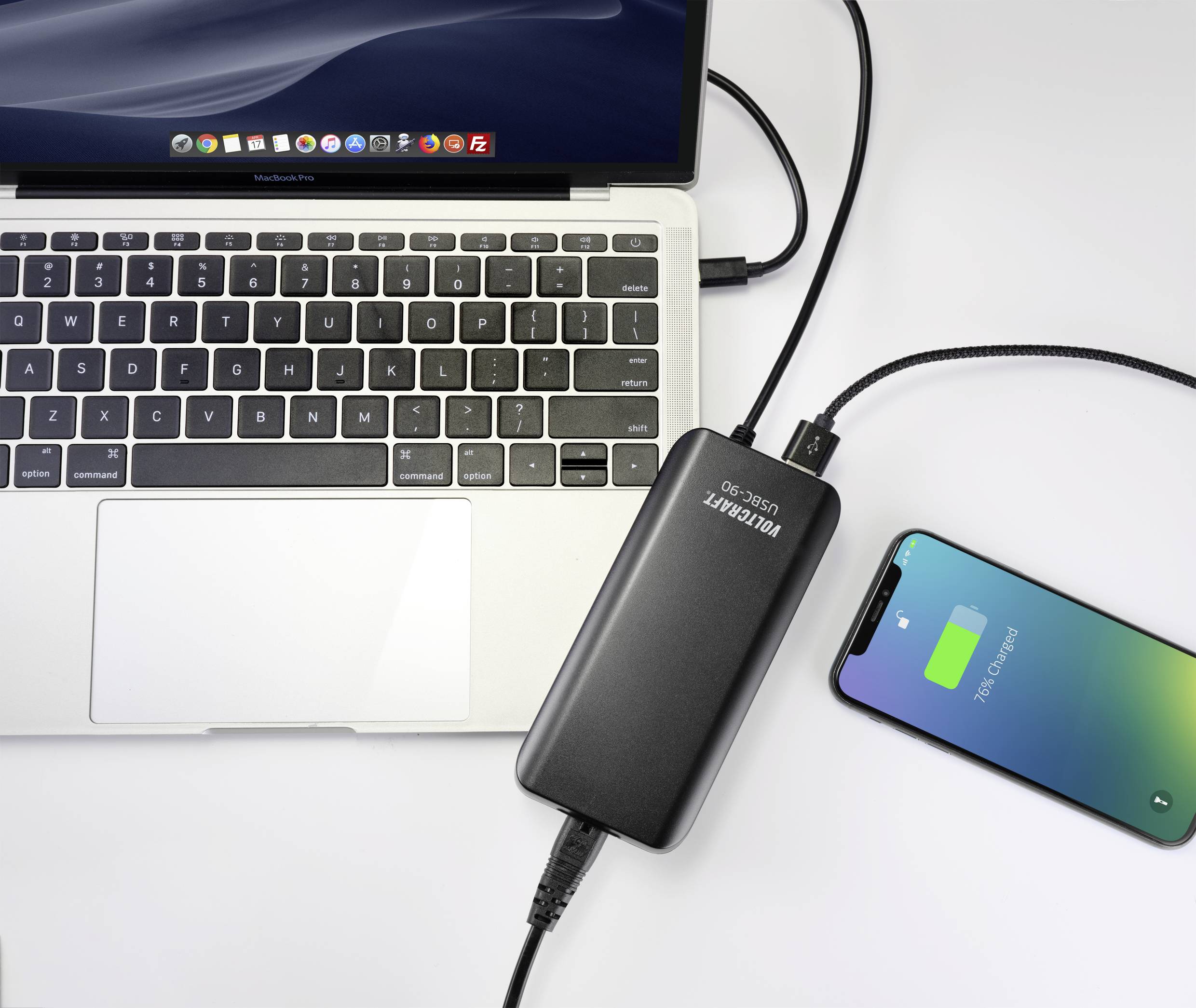 Ein Laptop und ein Smartphone sind über ein externes Akku-Pack verbunden. Der Akku des Smartphones zeigt an, dass es geladen wird.