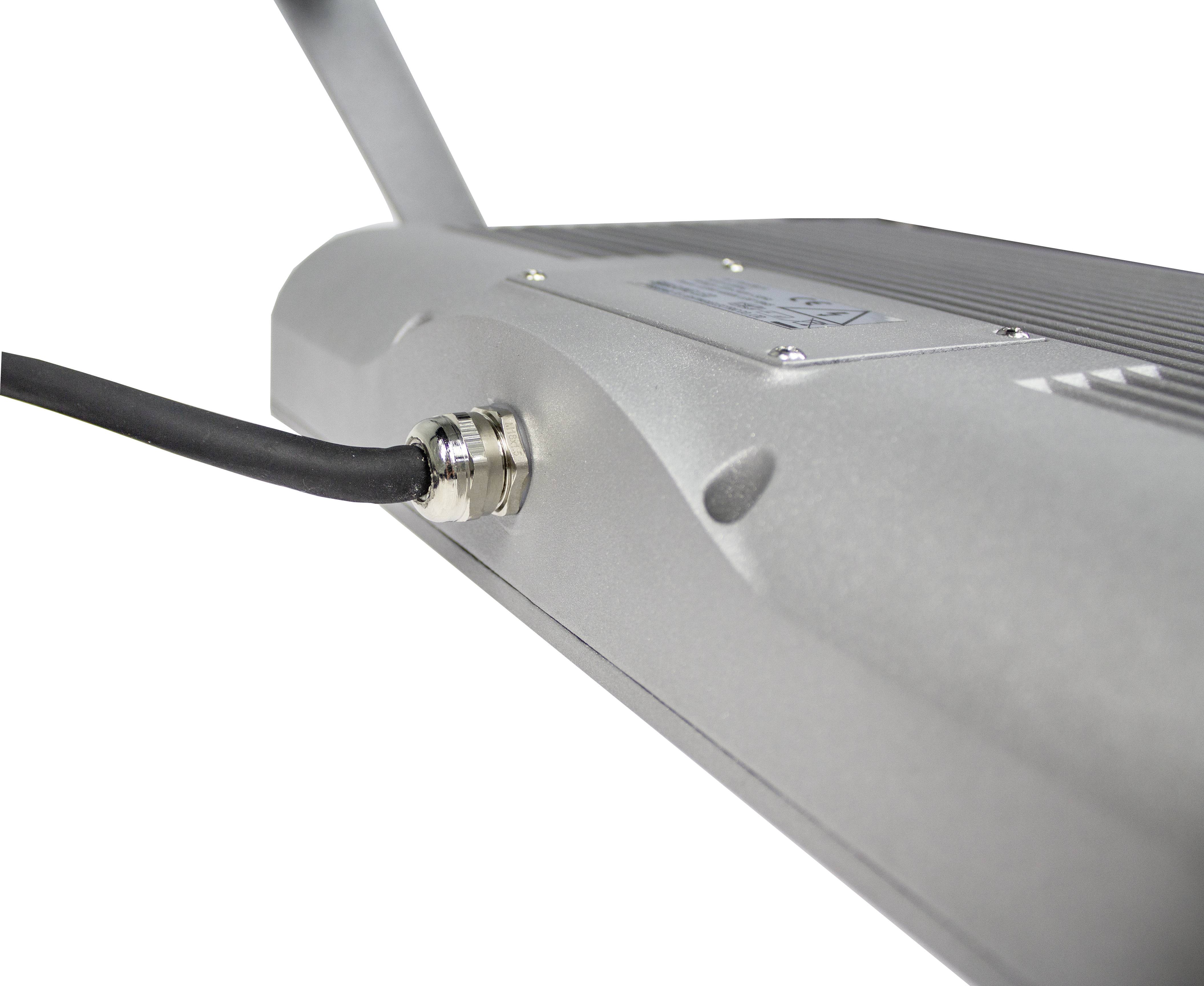 Ein silbernes elektronisches Gerät mit einem angeschlossenen schwarzen Kabel, das auf der linken Seite eines metallischen Gehäuses endet.