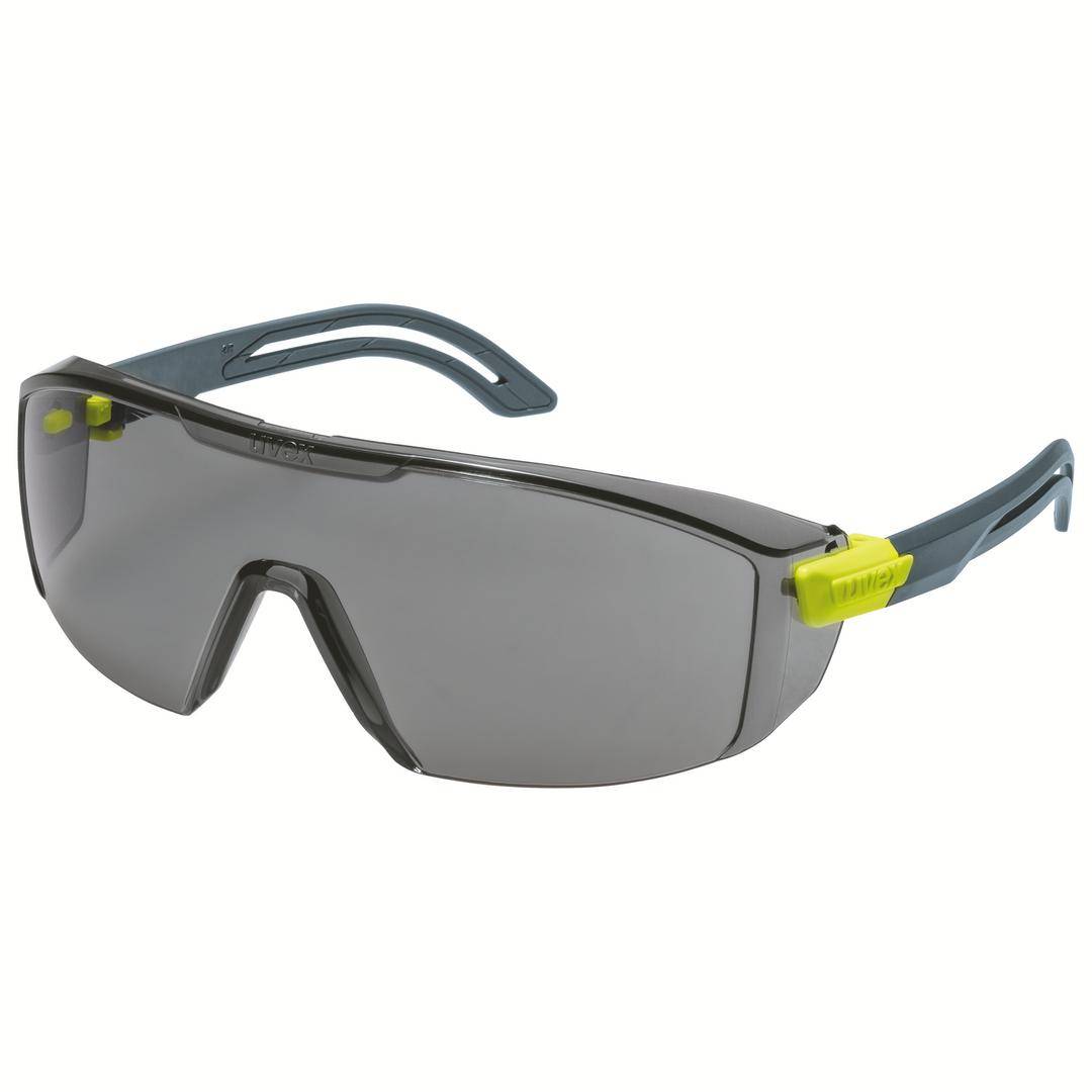Graue Sicherheitsbrille mit gelben Details und verdunkelten Gläsern, seitlicher Schutz, auf hellem Hintergrund.