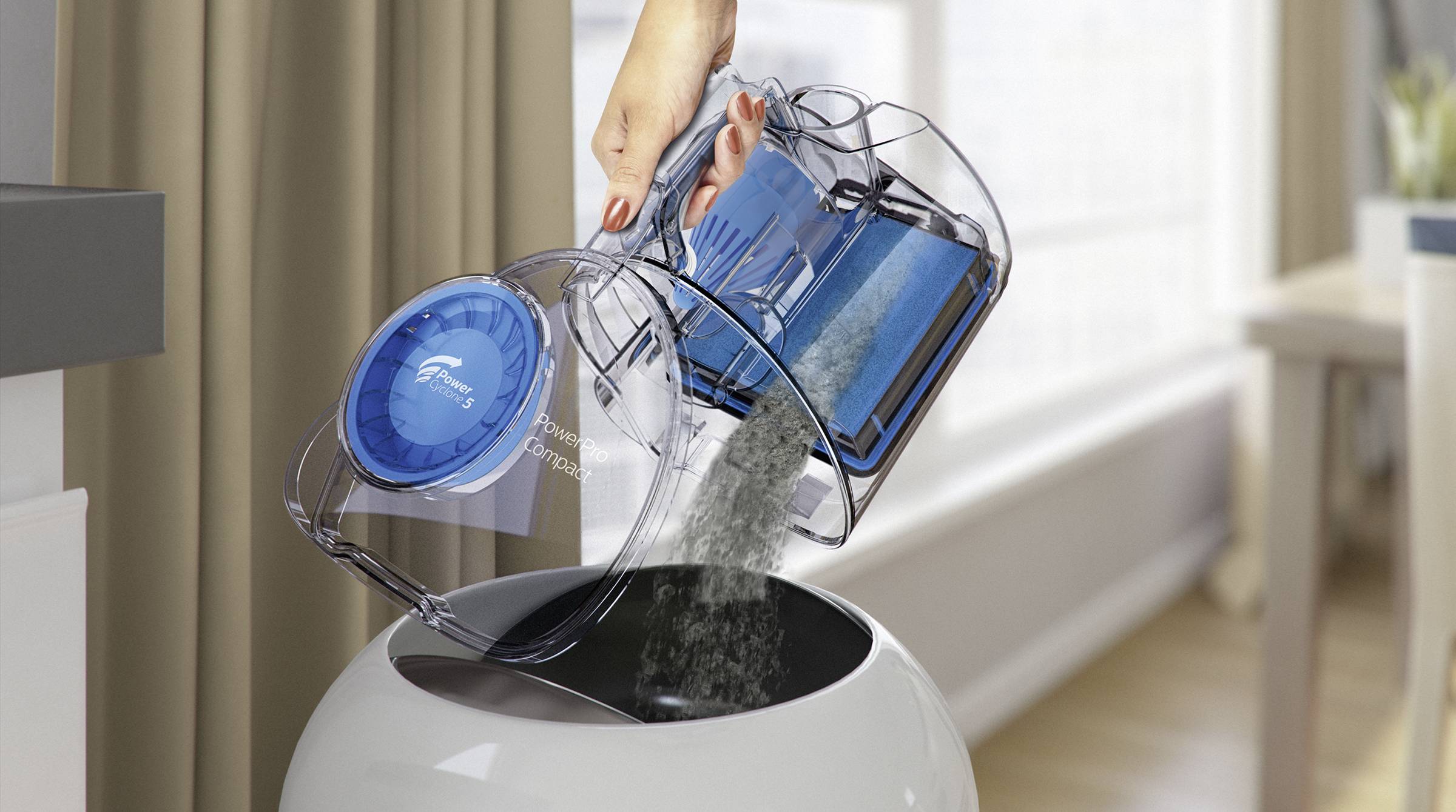 Eine Hand leert den Staubbehälter eines kabellosen Staubsaugers über einem Mülleimer. Der Staub fällt in den offenen Behälter.