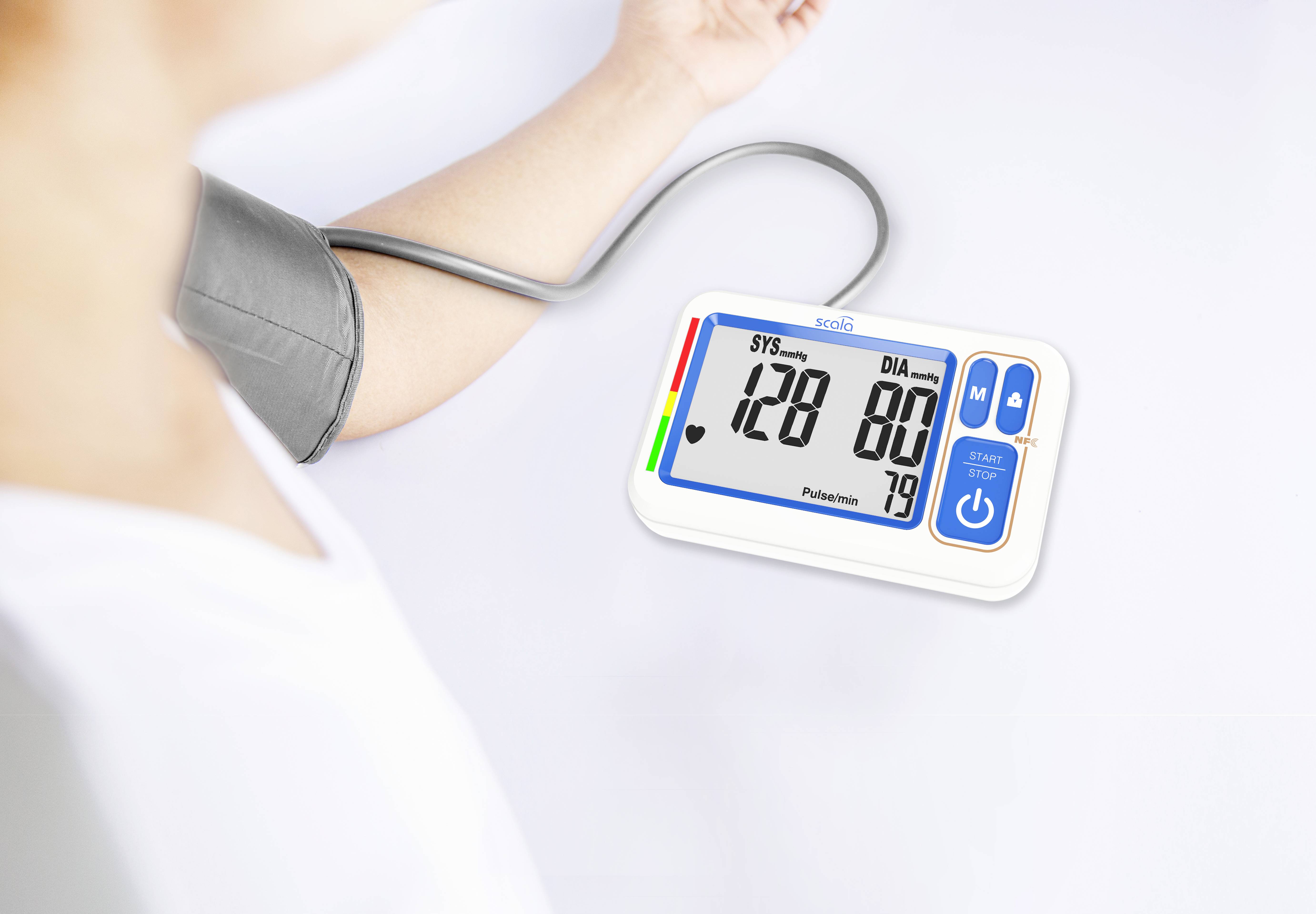 Eine Person misst den Blutdruck mit einem digitalen Gerät. Das Display zeigt 128 zu 80 und einen Puls von 79.