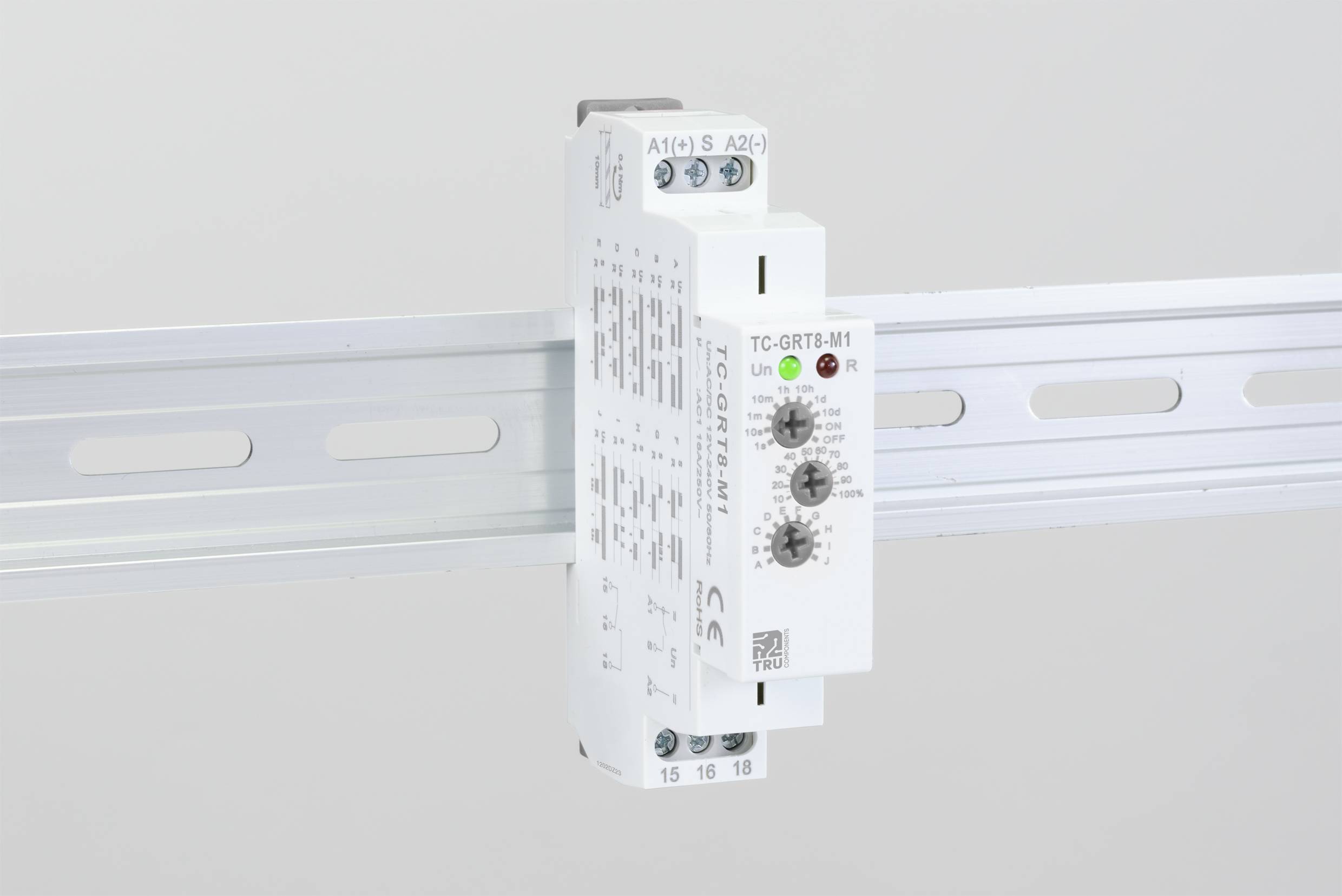 Ein elektronisches Gerät mit Drehpotentiometern ist auf einer DIN-Schiene montiert. Es hat LED-Anzeigen und technische Beschriftungen.